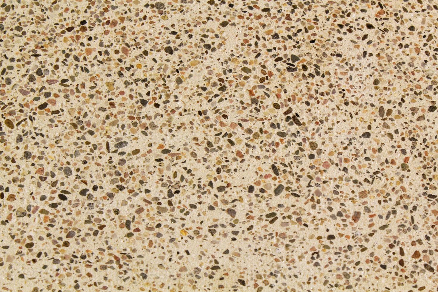 Concrete beige floor with multicolor marble and small natural crushed stones inserted. Pebbles textured background. Decorative rough surface granite. Gravel wall material. Little rock backdrop photo