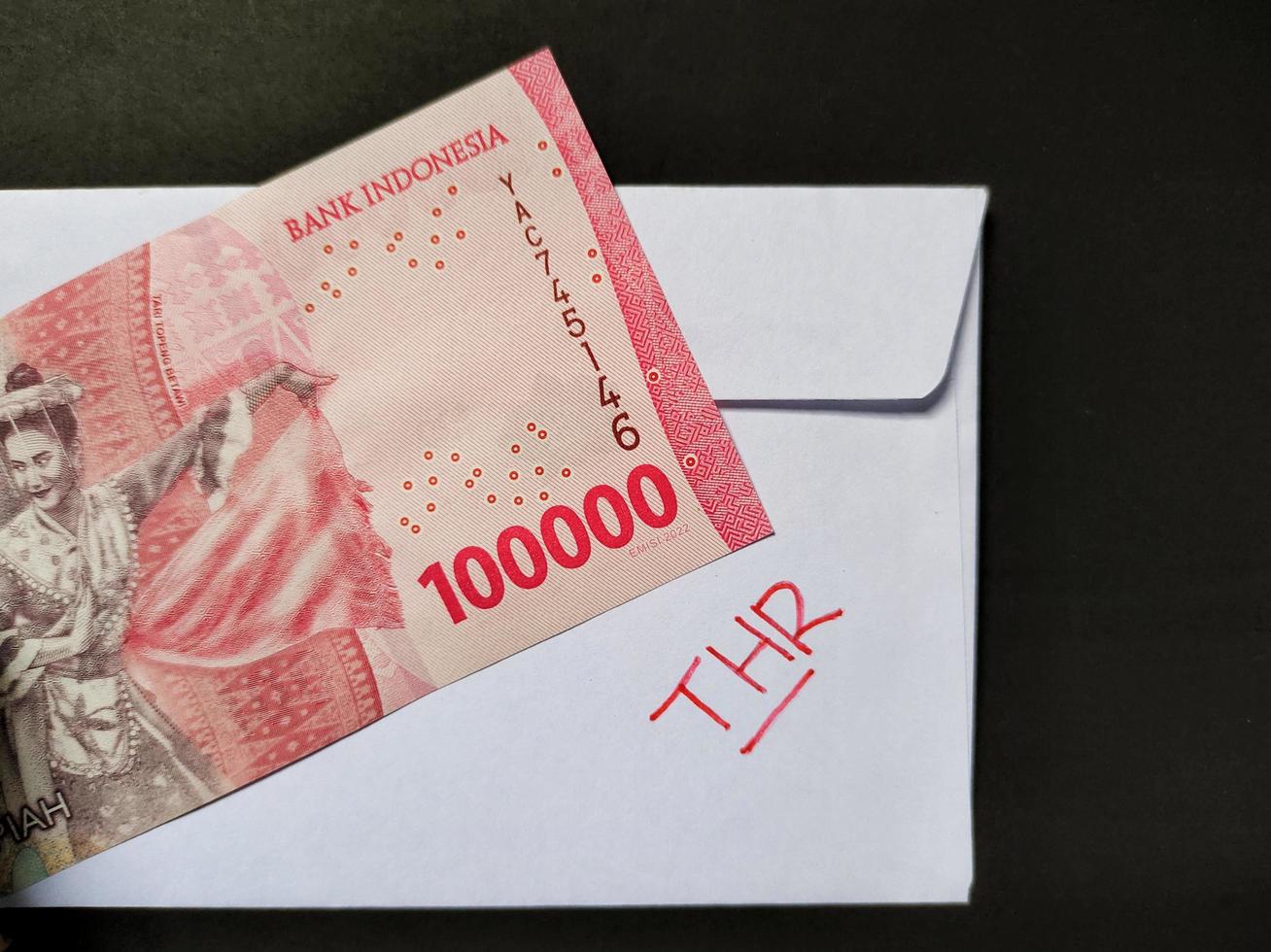 un blanco sobre escrito de thr y nuevo indonesio billetes de banco, por lo general tunjangan hari raya o llamado thr son dado a empleados adelante de Eid. foto