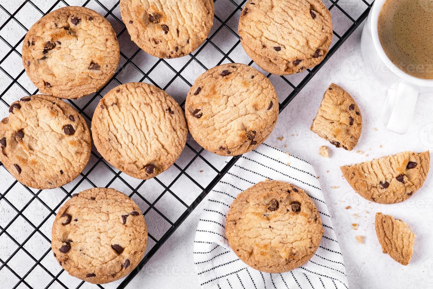 Oatmeal cookies on metal cooling rack and coffee in white mug photo