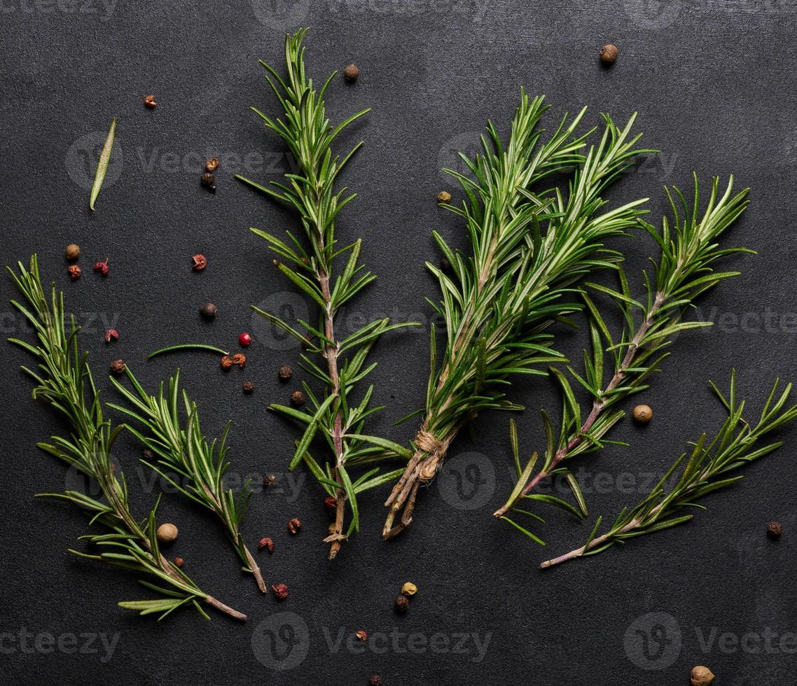 Sprigs of fresh rosemary on a black background, top view photo