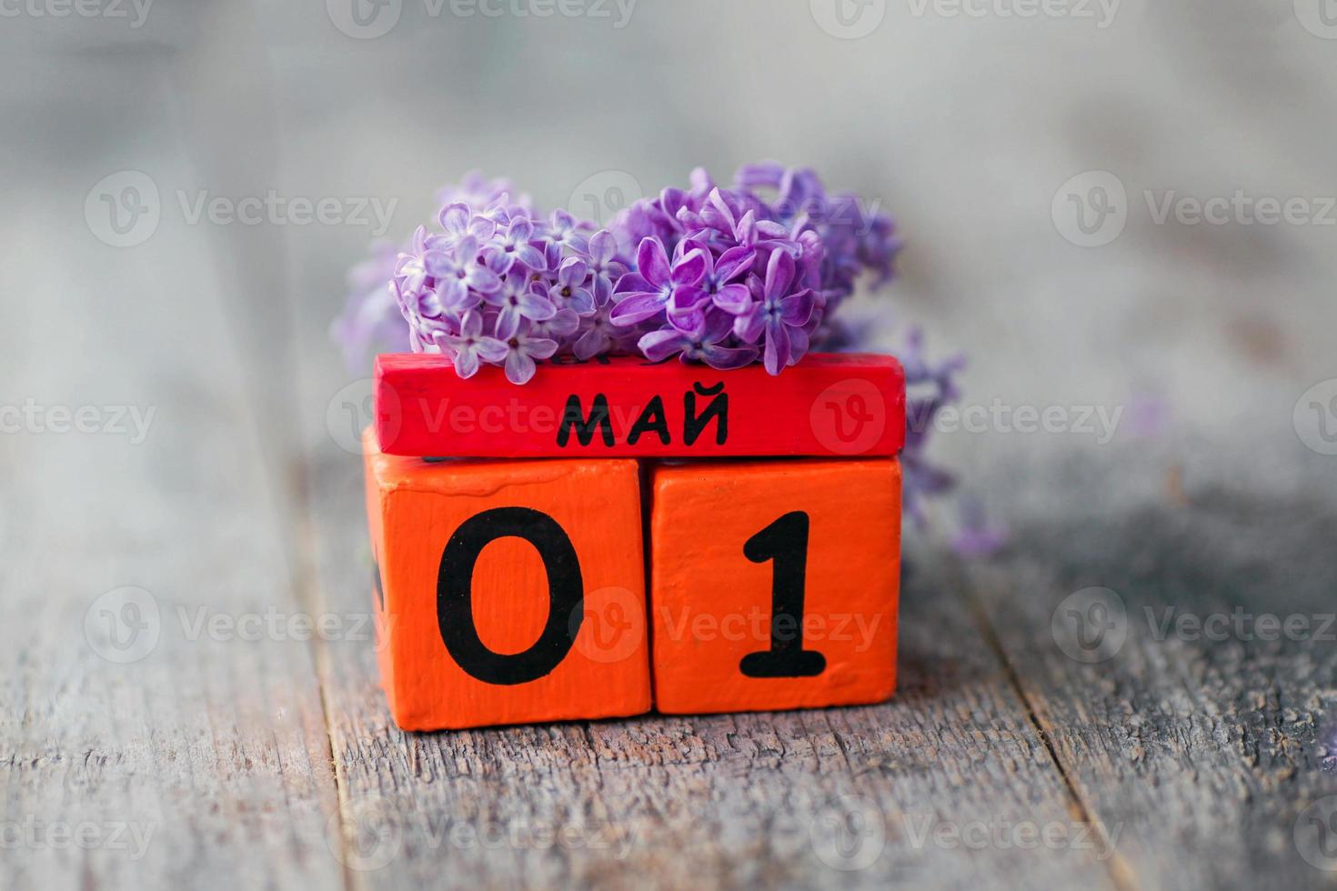 de madera calendario con ruso texto mayo 1 y un ramo de flores de lilas en un de madera antecedentes. primavera día, vacío espacio para texto. internacional de los trabajadores día foto