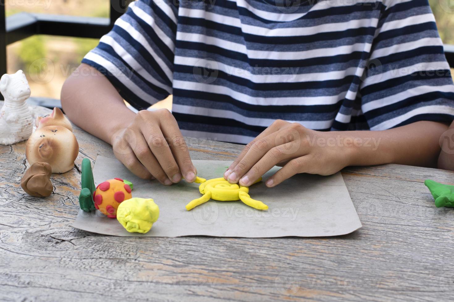 An autistic boy molding different shapes of colored plasticine prepared by parents at home in order to develop various aspects in their son which has slower brain development than normal children. photo