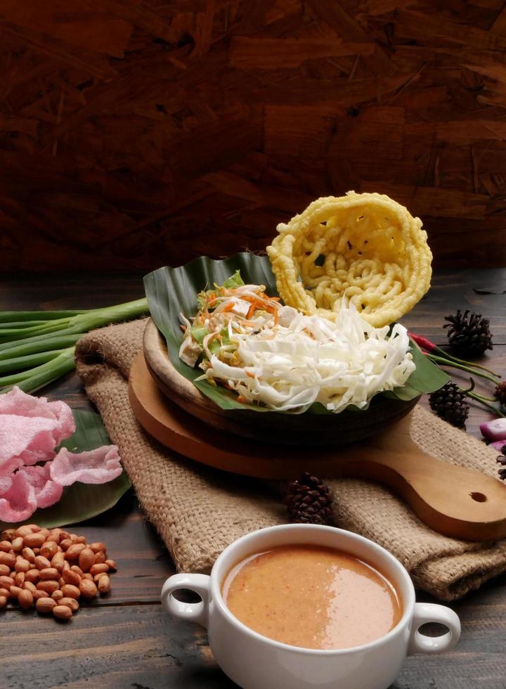 Selective focus of Asinan Betawi. The vegetable asinan of the Betawi people from Jakarta is preserved Chinese cabbage, cabbage, bean sprouts, tofu, and lettuce served with peanut sauce and krupuk photo