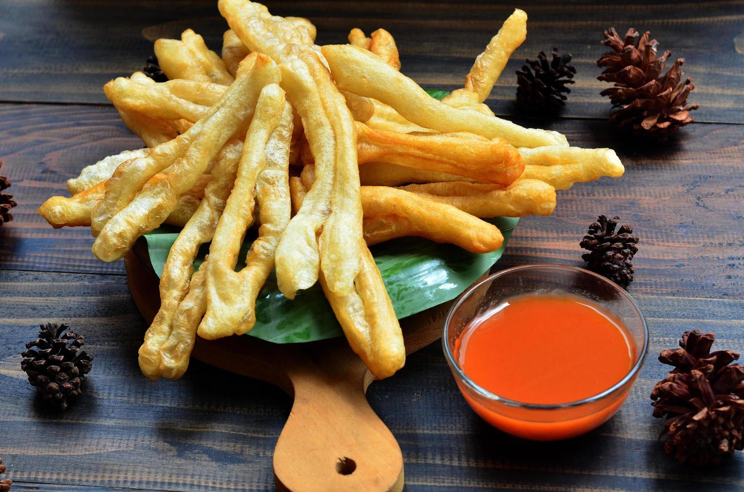 A plate of Cakwe or Cakue with chilli sauce at wooden table. Cakwe is a popular traditional snack from Chinese and indonesia photo
