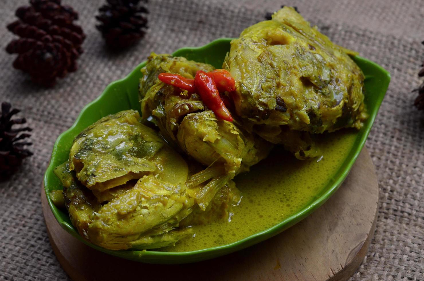 gulai kepala kakap o pargo pescado cabeza, cocido en curry Condimento, eso sabores picante, agrio y sabroso. tradicional padang cocina, Oeste Sumatra, Indonesia. foto