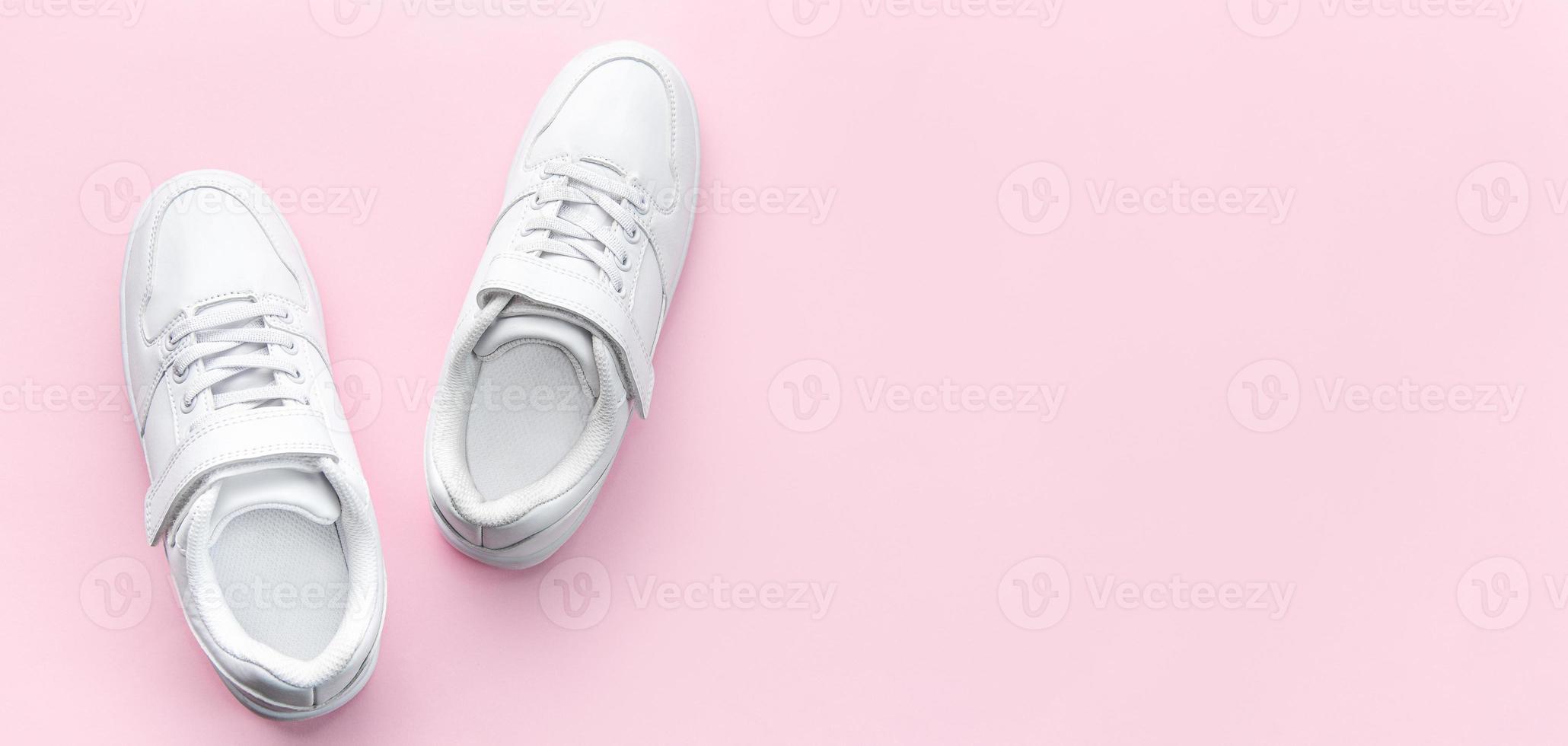 White sneakers on a pink background. photo