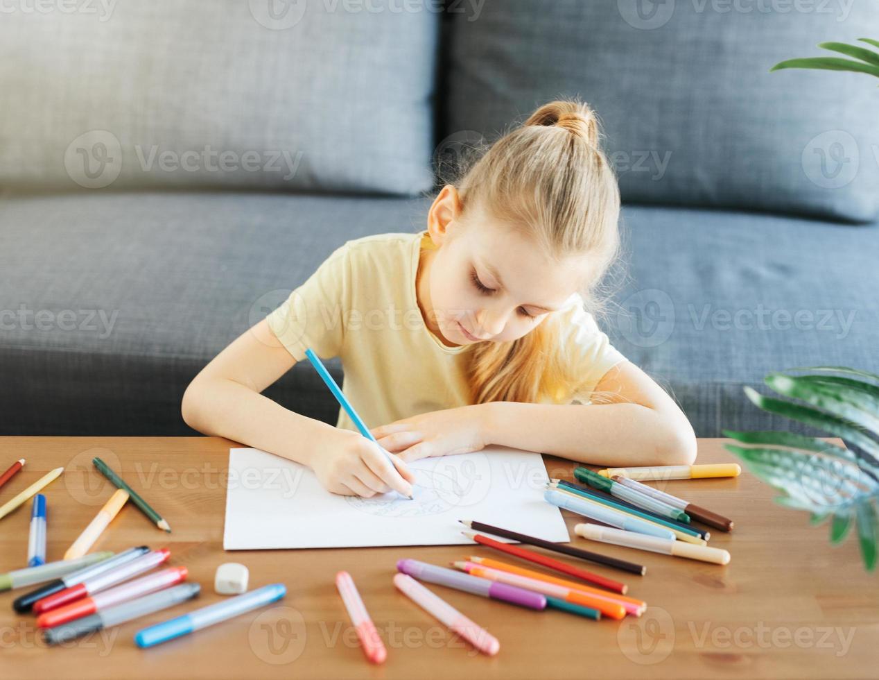 Child girl drawing with colorful pencils photo