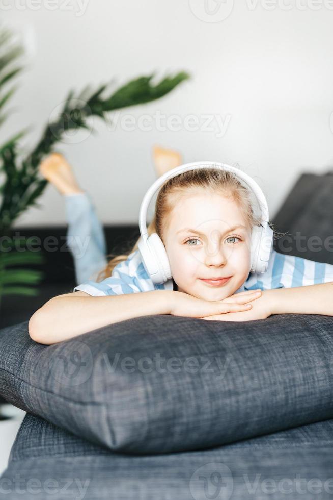 Cute little girl listening to music in headphones photo