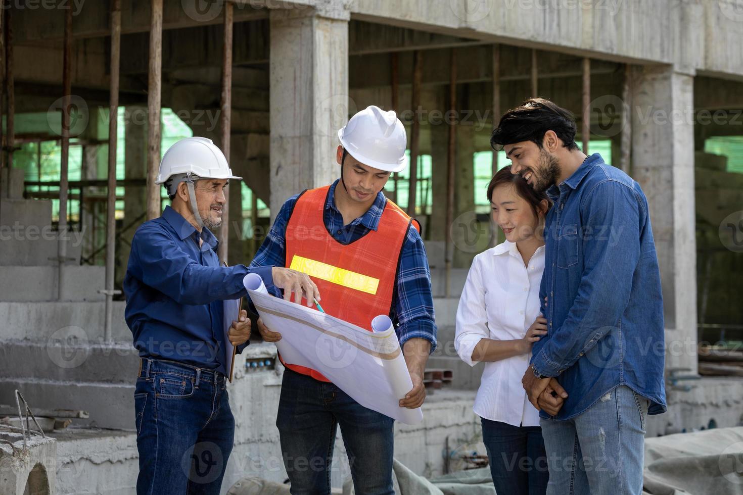 Newly wed couple is meeting with engineering contractor at their under construction house to inspect the building progress and quality control for home ownership and real estate development concept photo