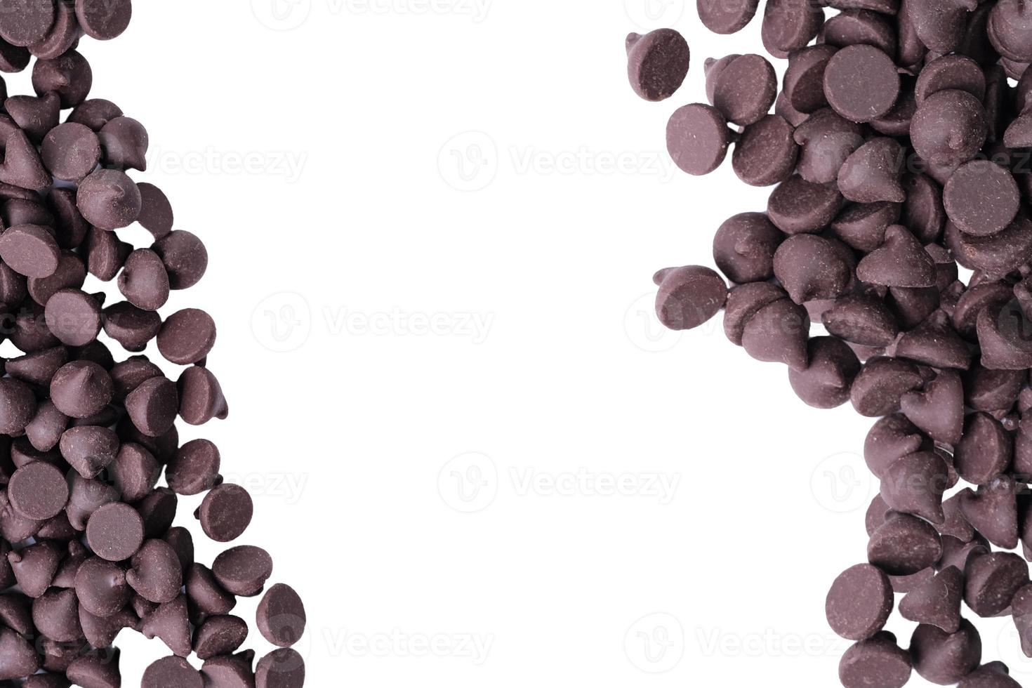 Close up of a pile of scattered chocolate chips on a white background photo
