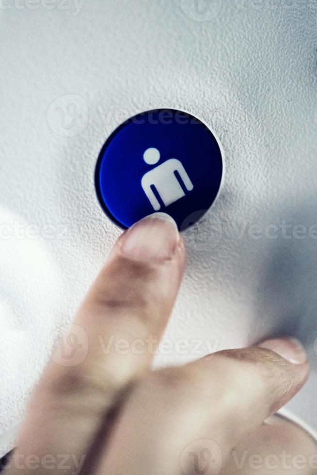 The passenger presses a button on the panel above her head to turn on the air conditioner fan and lighting in the interior of the aircraft photo