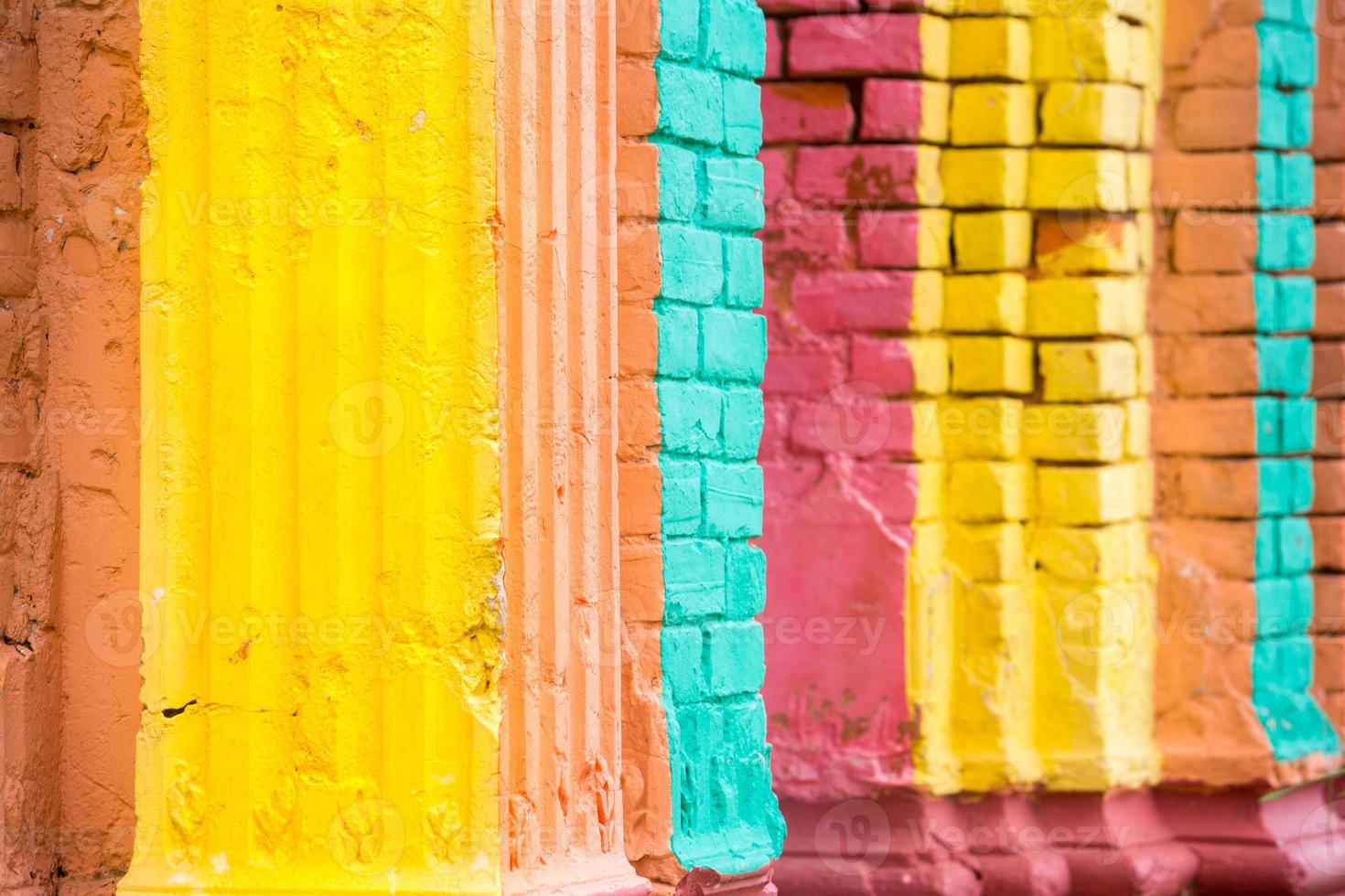 Red, Orange, yellow and blue color combination old Textured damage wall with Colorful Bricks. photo