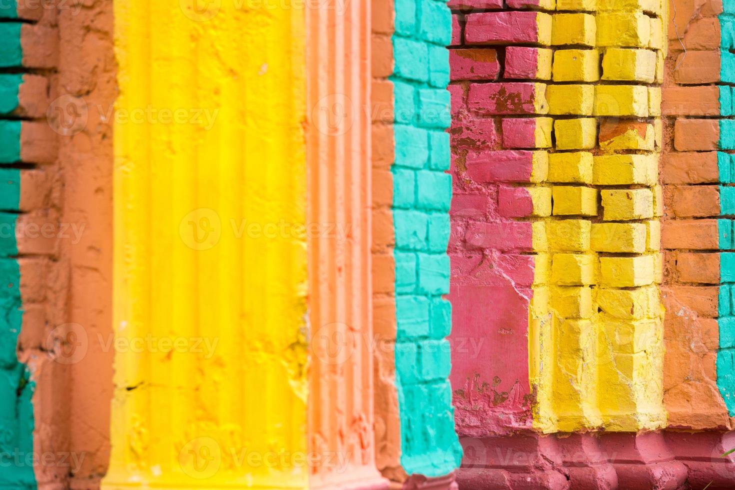 Red, Orange, yellow and blue color combination old Textured damage wall with Colorful Bricks. photo