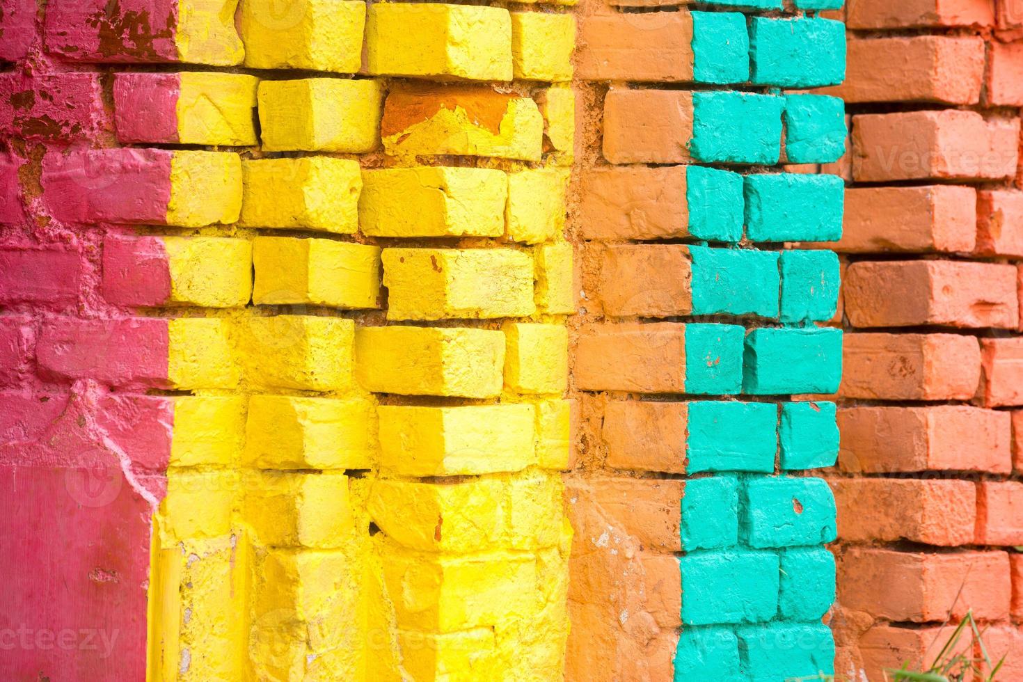 Red, Orange, yellow and blue color combination old Textured damage wall with Colorful Bricks. photo