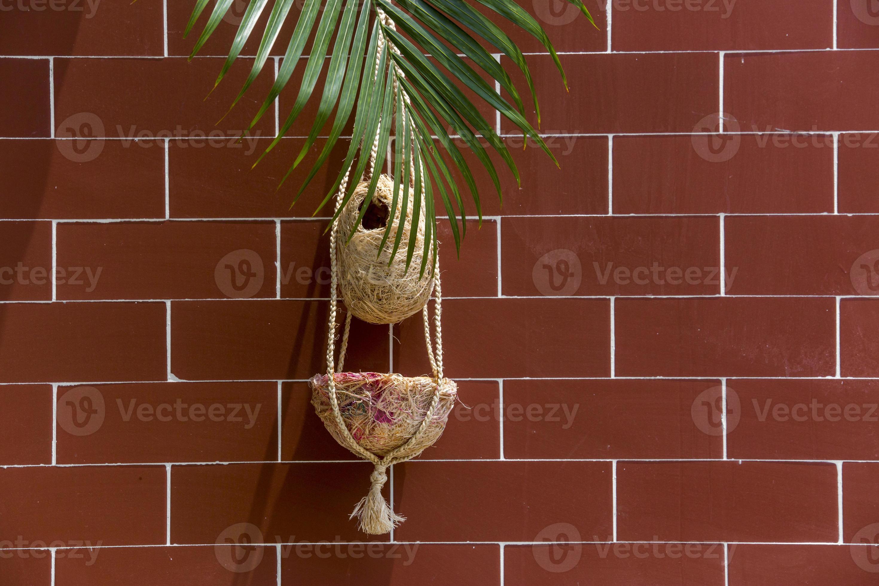Handmade birds nest are hanging on the bricks wall. Interior Decoration