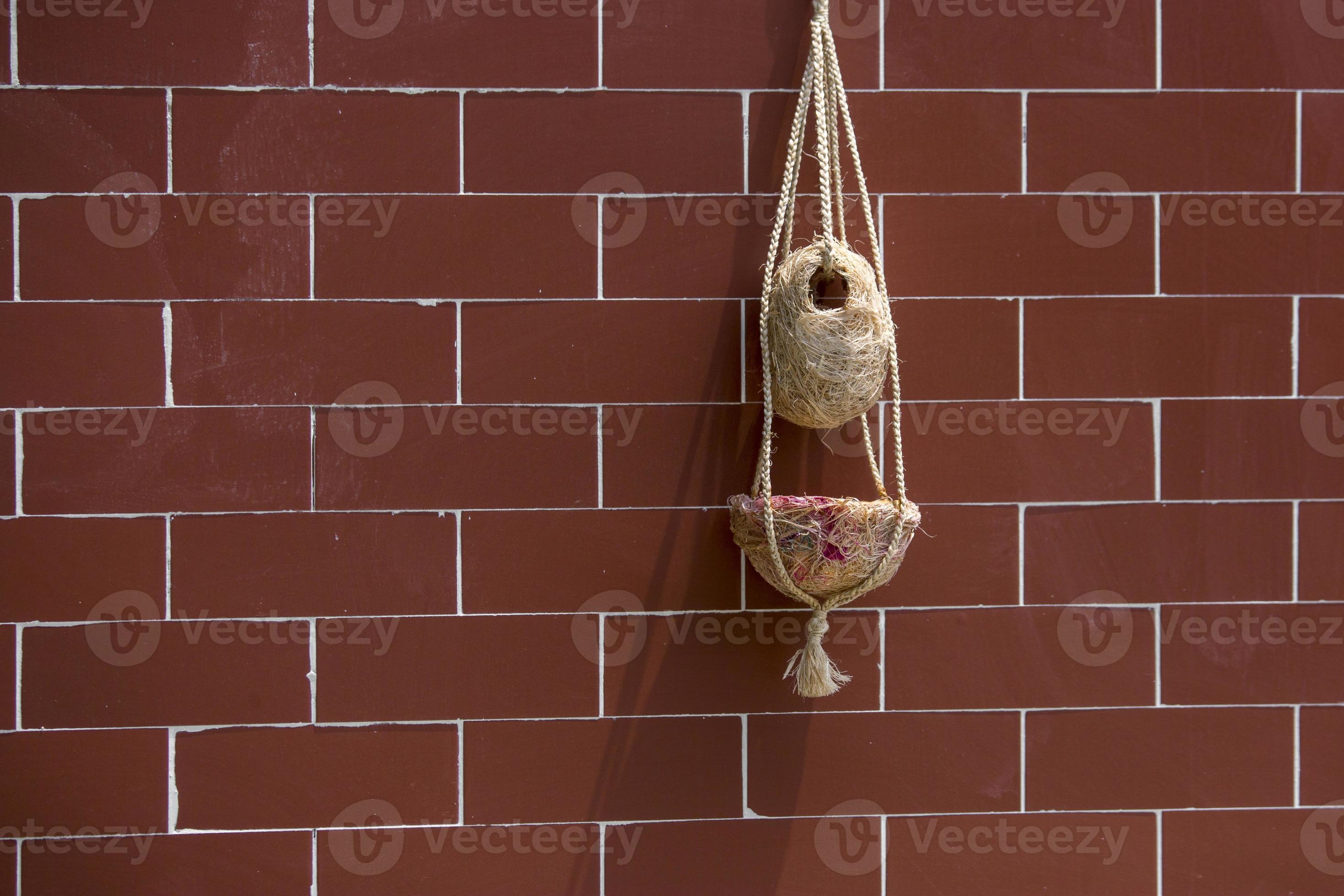 Handmade birds nest are hanging on the bricks wall. Interior Decoration