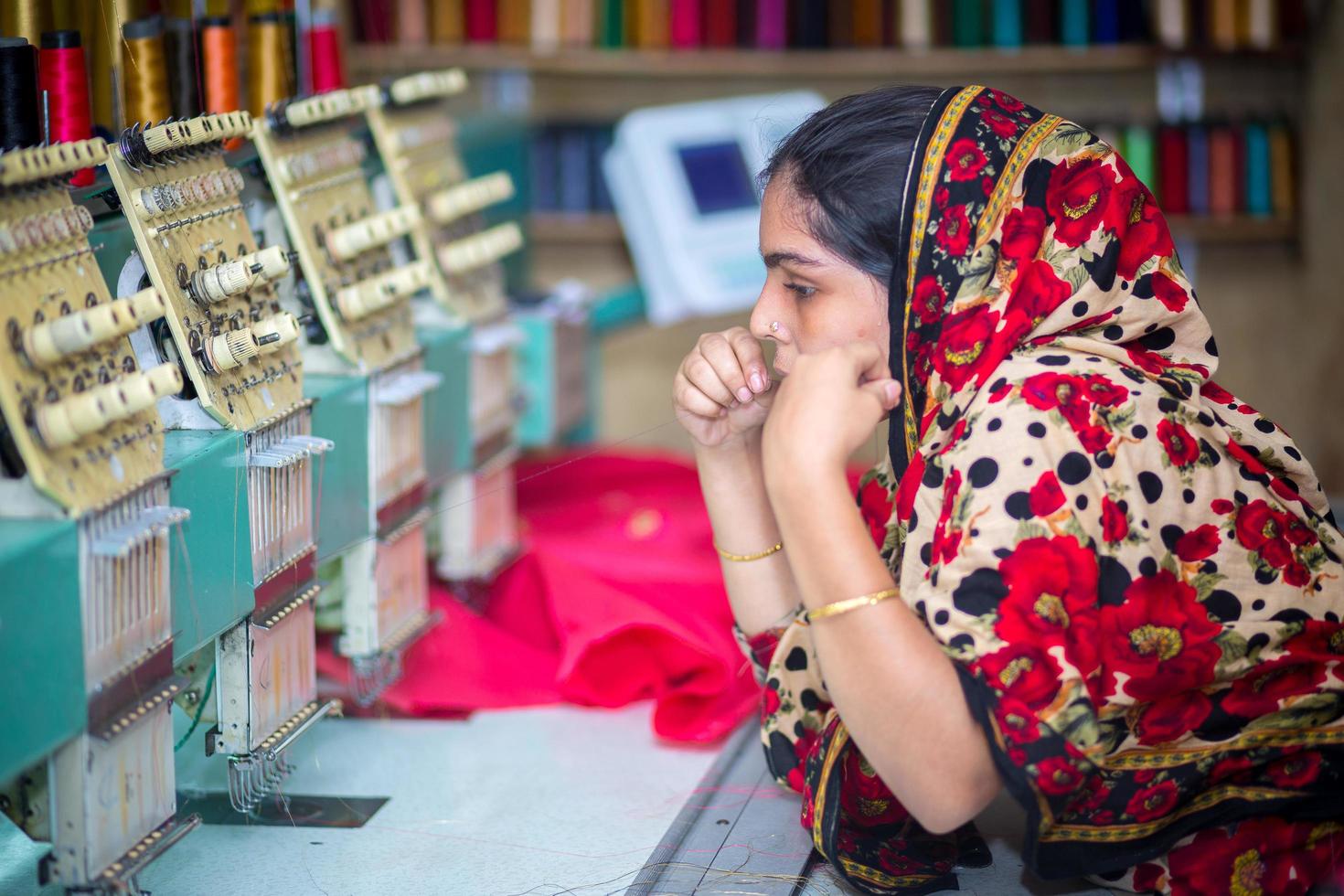 Bangladesh agosto 6, 2019, un bangladeshi mujer vestidos trabajador trabajando con computerizado bordado máquina a madhabdi, narsingdi, bangladesh foto