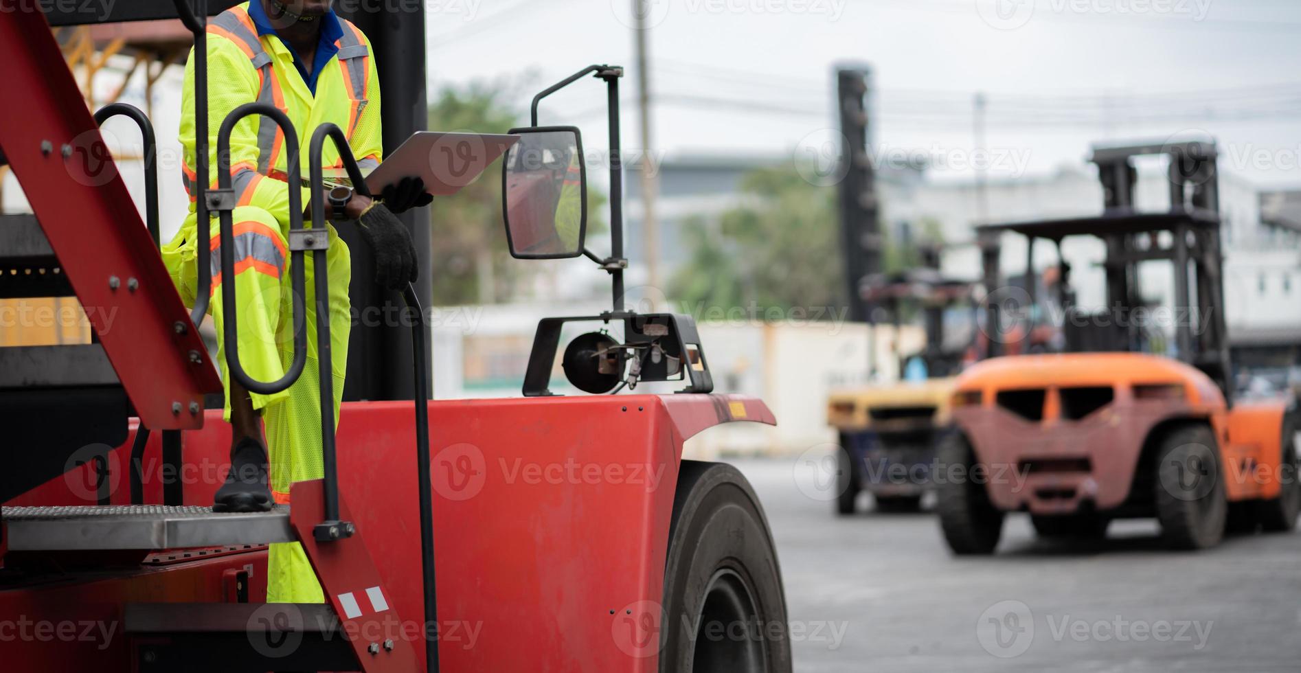 engineer man worker in protective safety jumpsuit uniform with yellow hardhat and use laptop check container at cargo shipping warehouse. transportation import,export logistic industrial servic photo