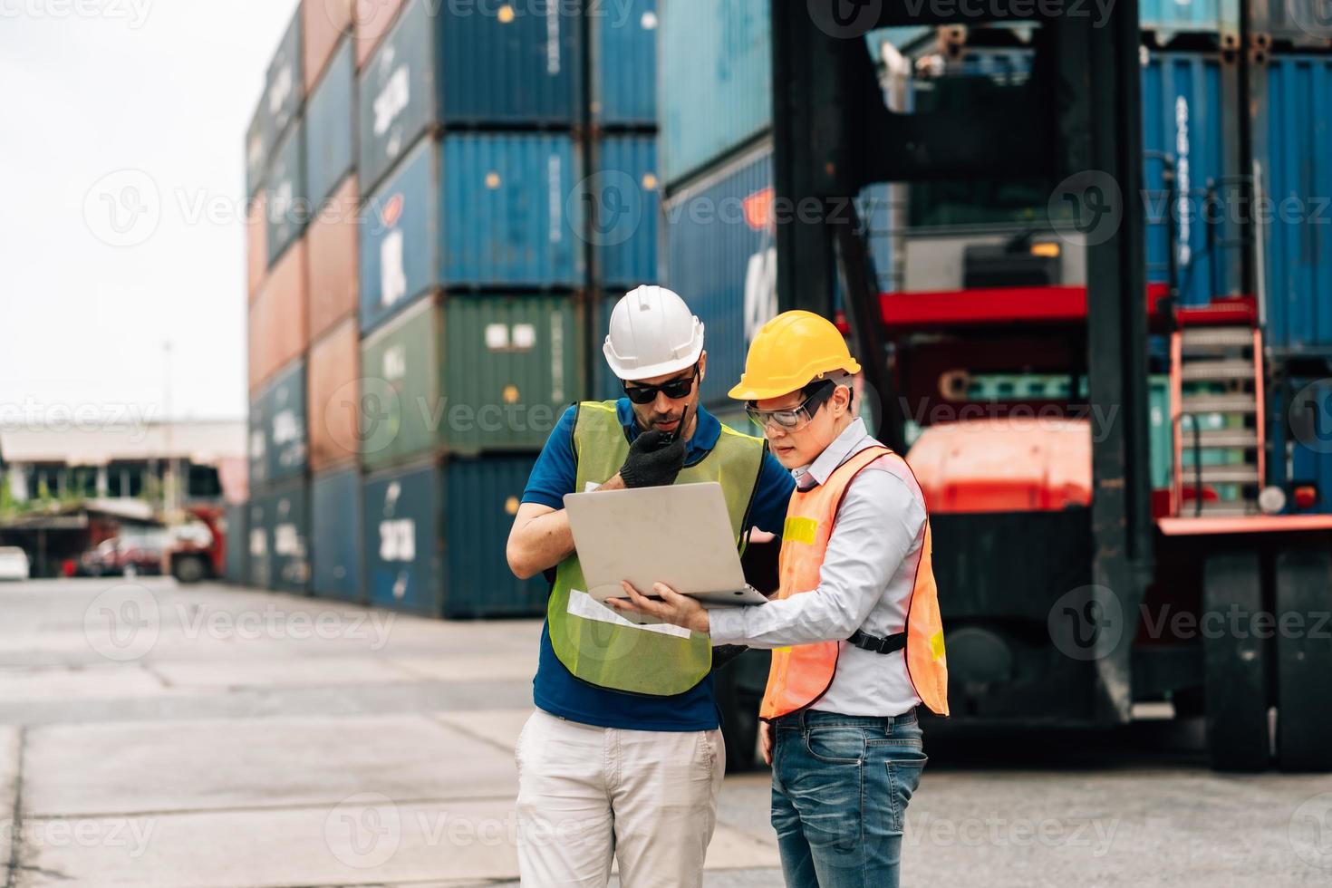 Team Engineer and worker wear safety uniform check control loading freight cargo container use computer laptop at commercial dock warehouse,transportation import,export logistic industrial service photo