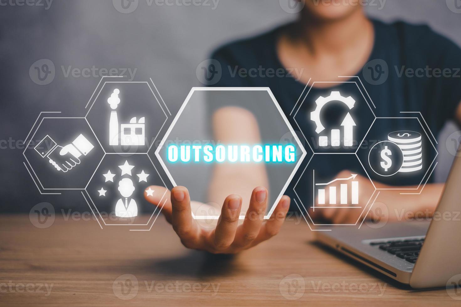 Outsourcing Global Recruitment Business and internet concept, Business person hand holding outsourcing icon on virtual screen with blue bokeh background. photo