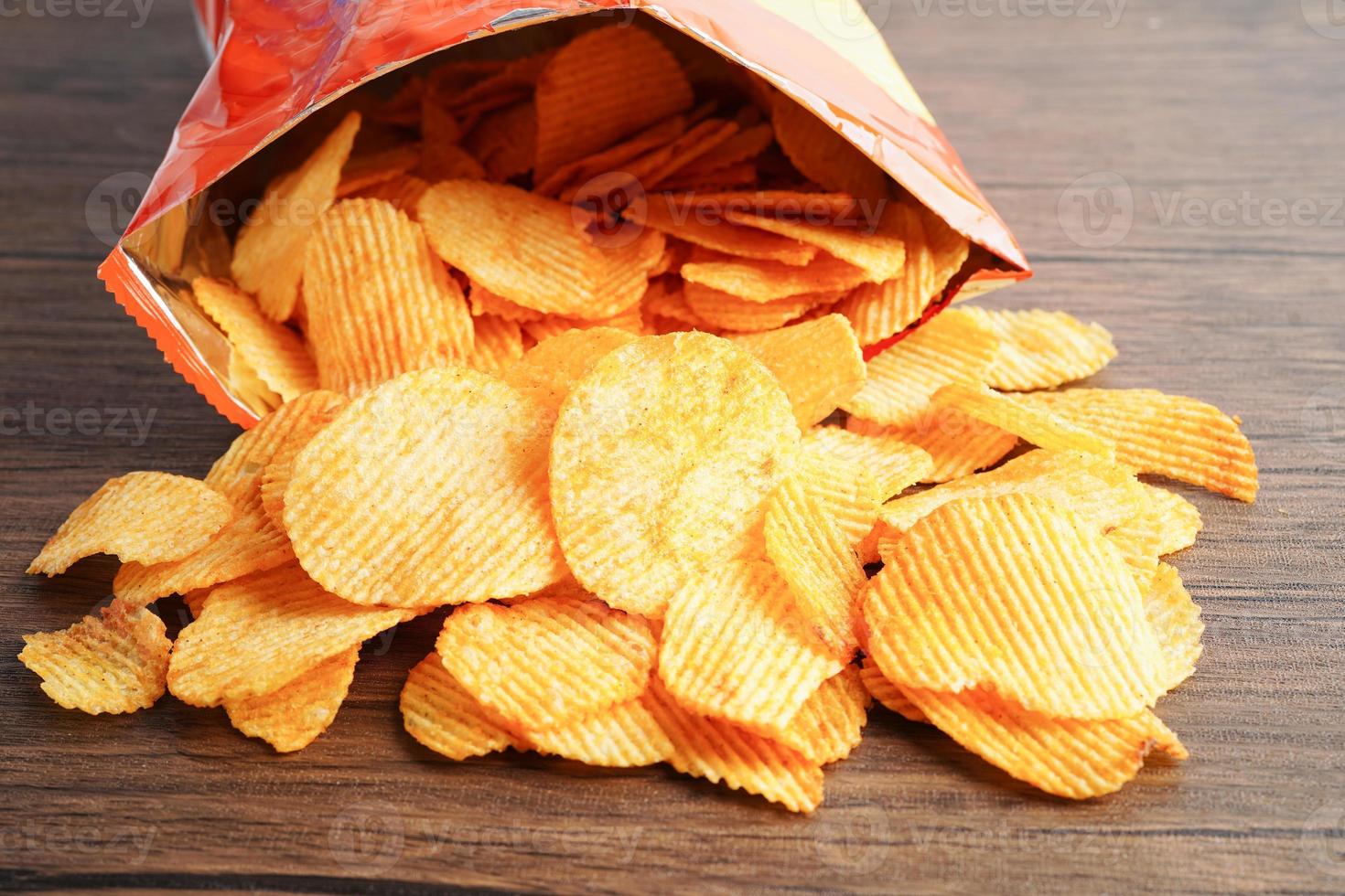 Potato chips in open bag, delicious BBQ seasoning spicy for crips, thin slice deep fried snack fast food. photo