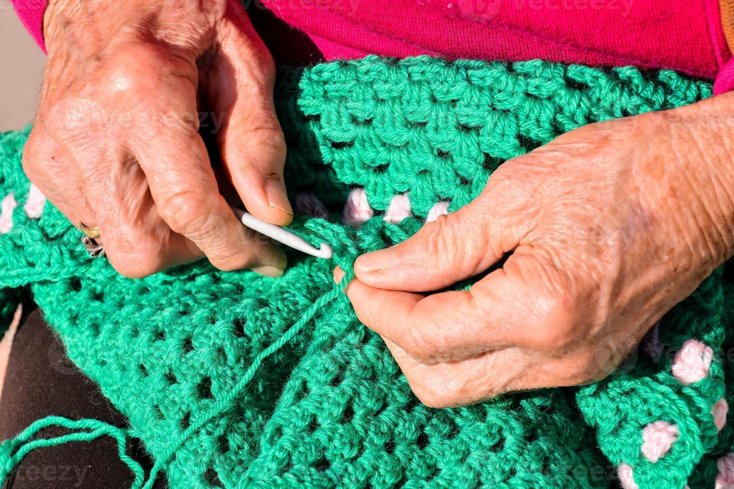 old woman with knitting needles and wool photo