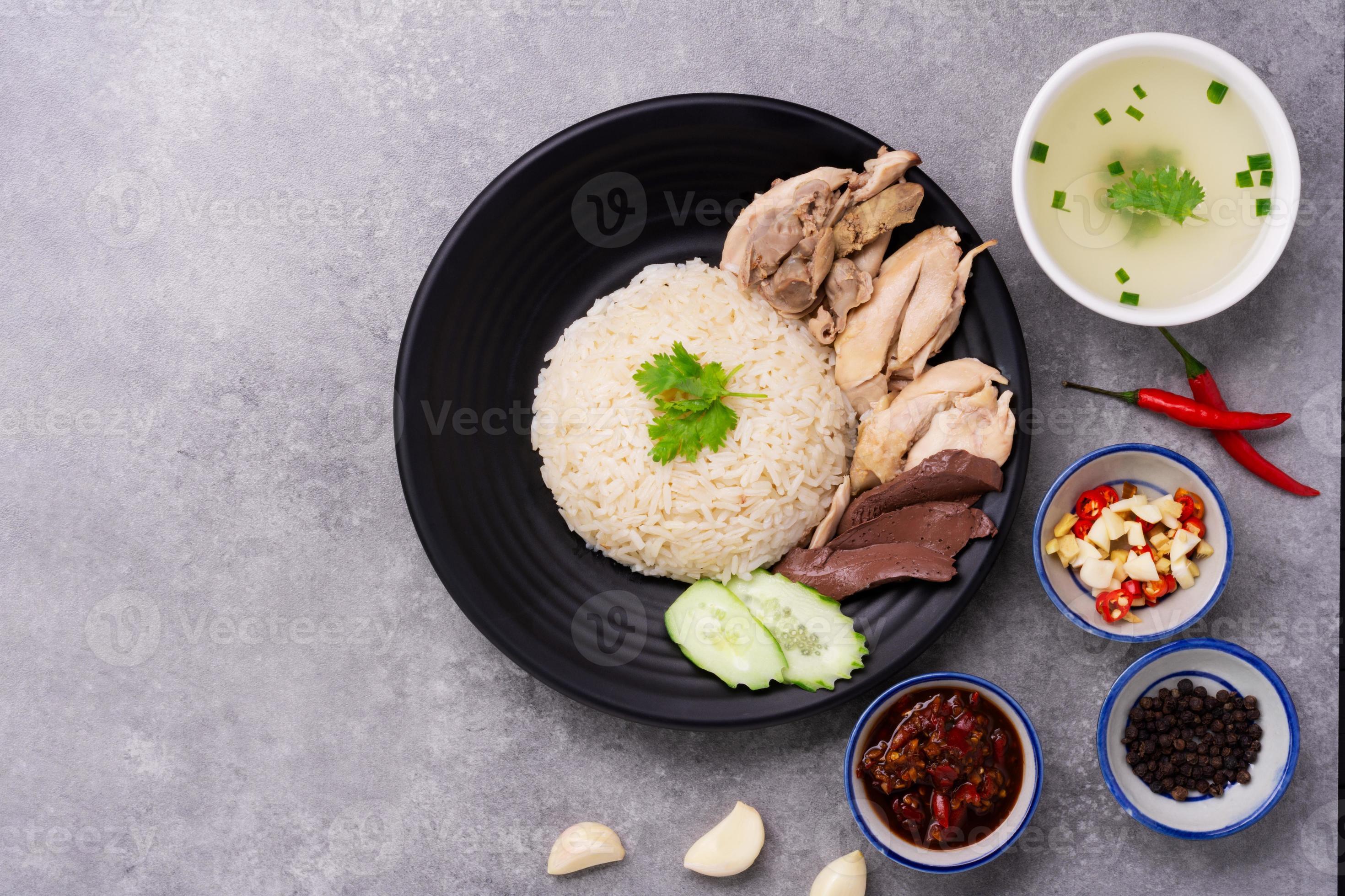 Hainanese chicken rice on a black wooden table background steamed chicken rice with chicken soup
