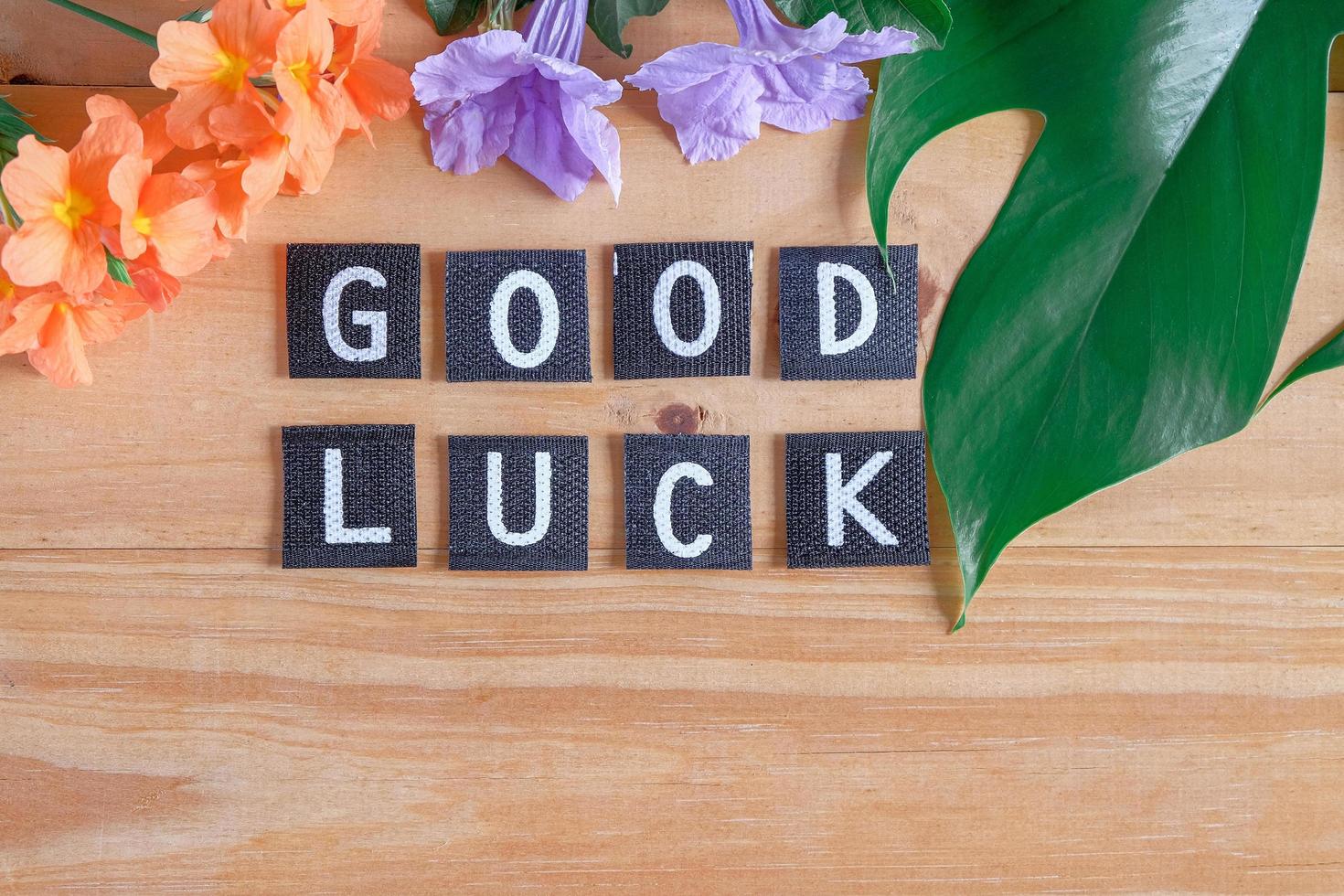 Good luck tag with flower on wood table. photo