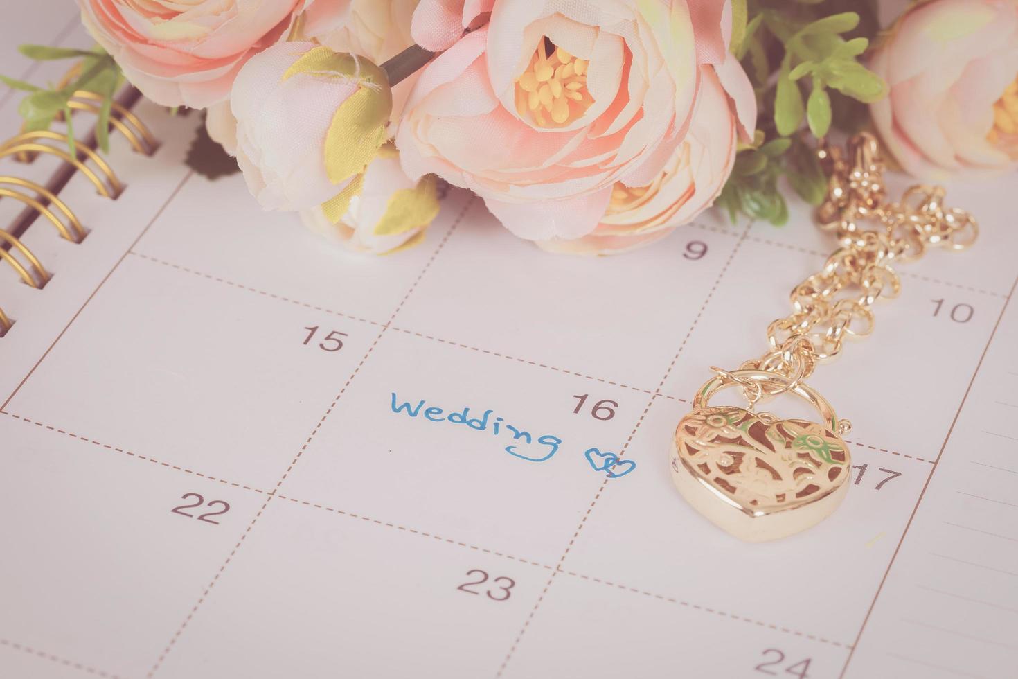 word wedding on calendar and gold bracelet with heart photo