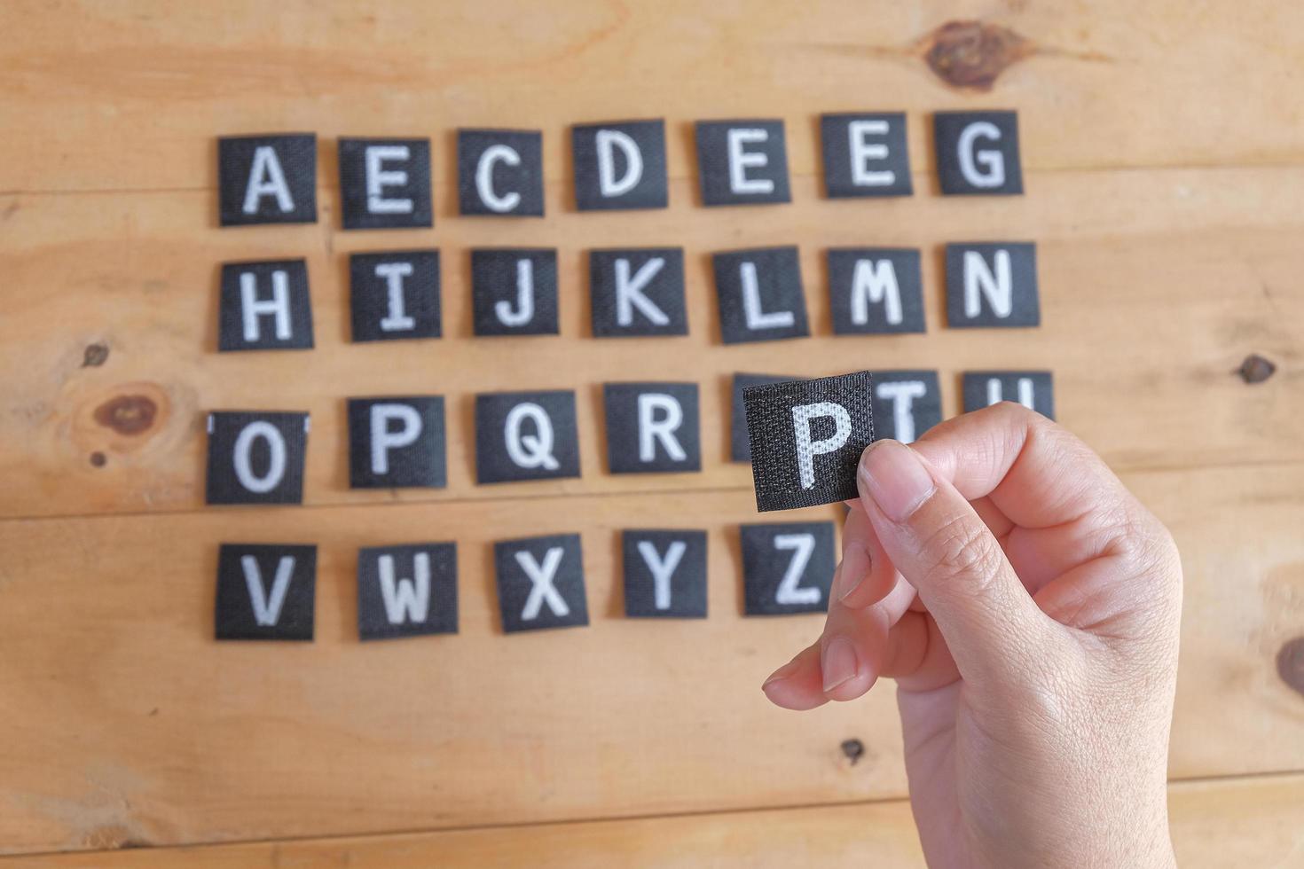 mano sostener un Inglés alfabeto letras . foto