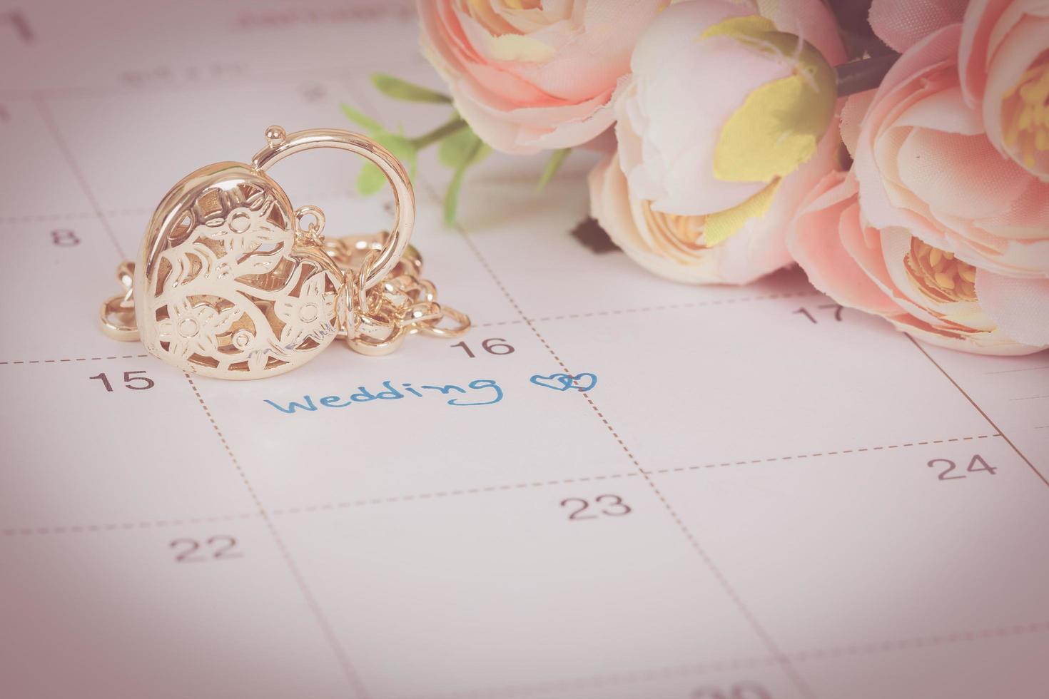 word wedding on calendar and gold bracelet with heart photo