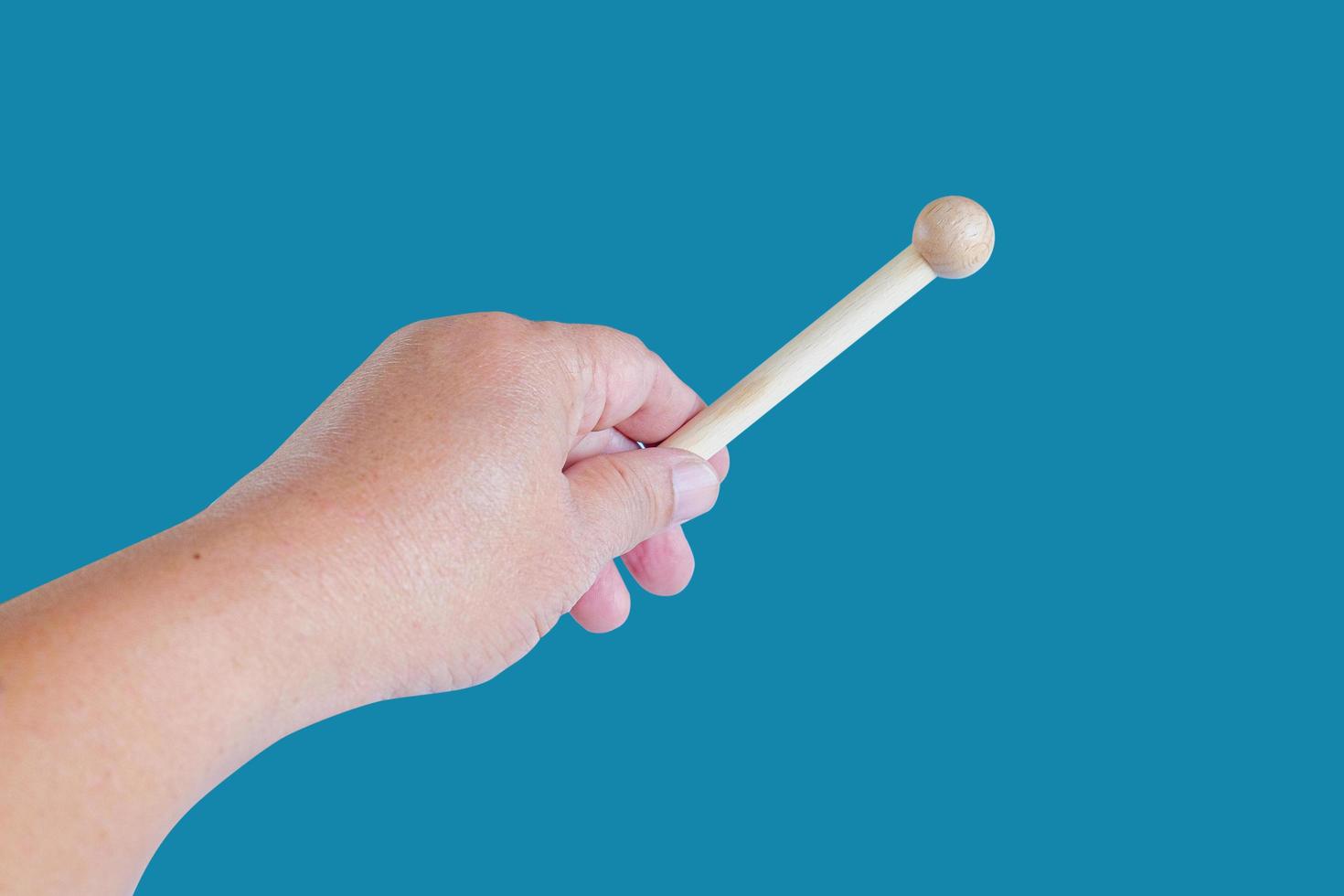 Hand holding a Woodenstick ,drumstick  on background. photo