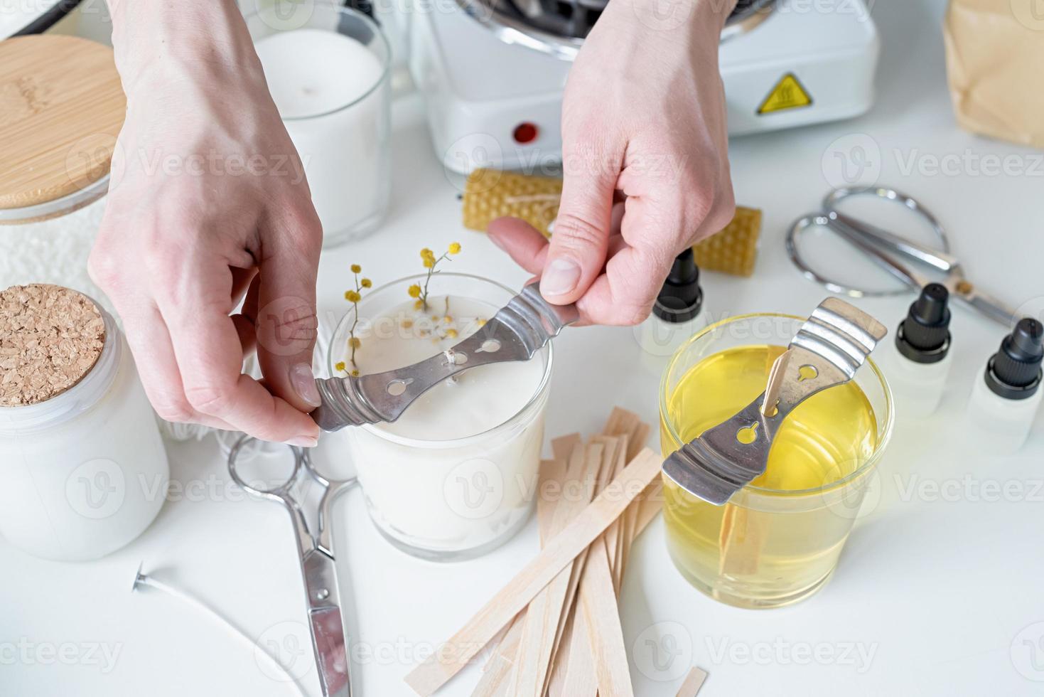 closeup of woman setting the wooden wick into handmade candle photo