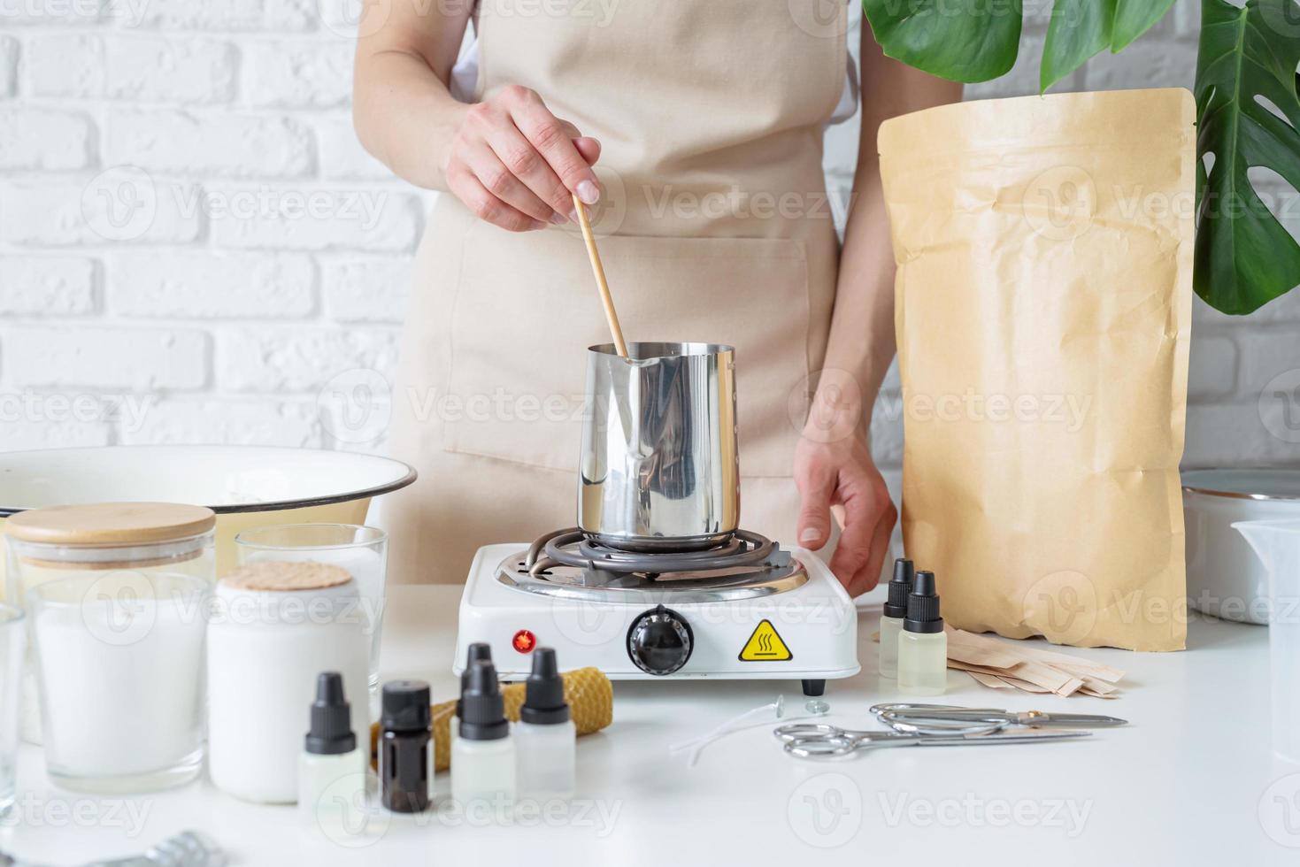 Woman making decorative aroma candles at table photo