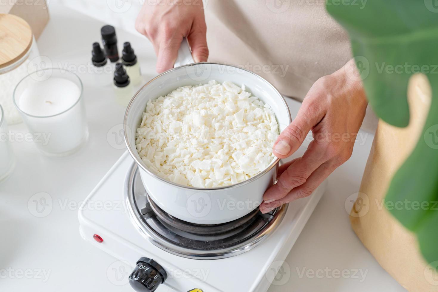 Woman making decorative aroma candles from soy wax photo