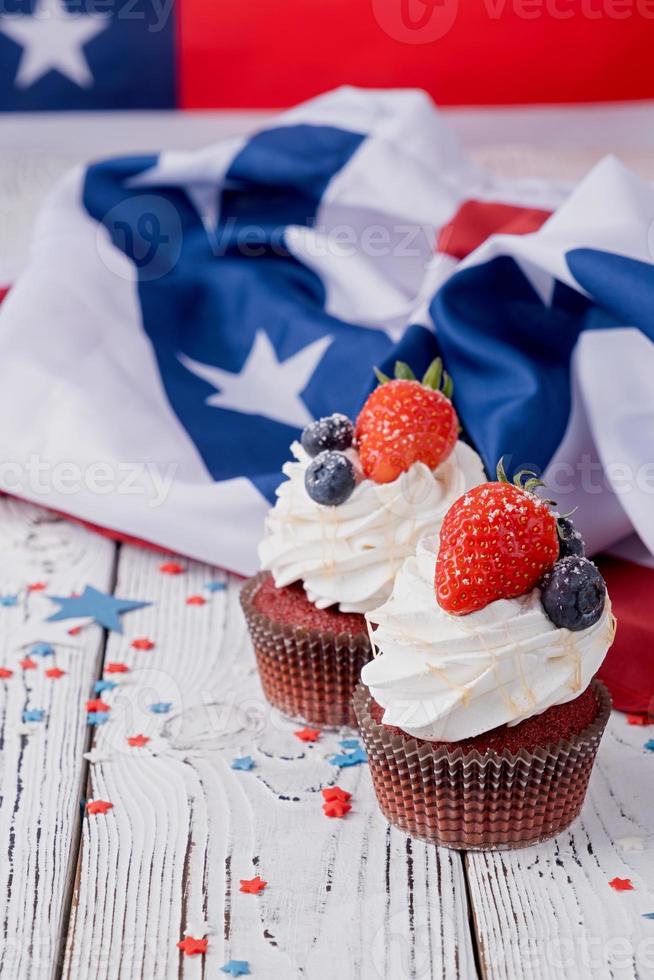 Sweet cupcakes with blueberries and strawberry , flag background photo