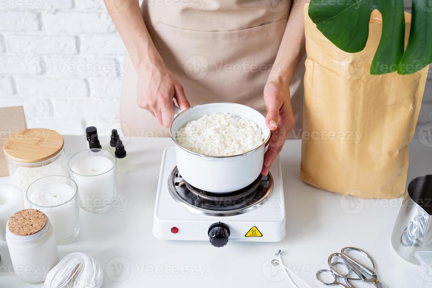 Woman making decorative aroma candles from soy wax photo