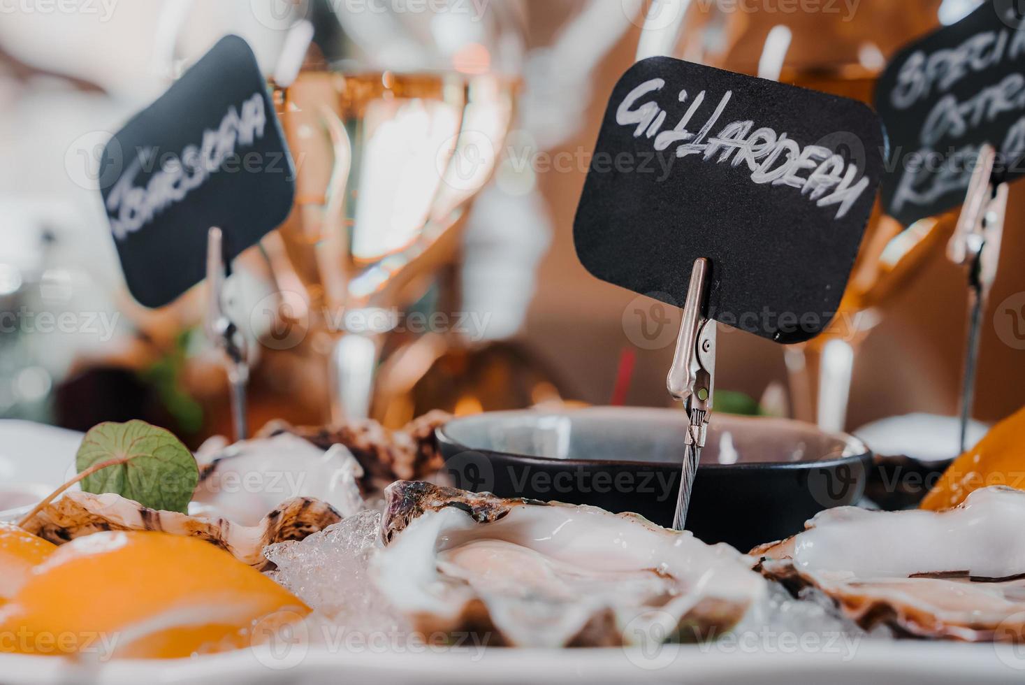 Fresh Oysters close up on a plate, served table with oysters, lemon and ice. Healthy sea food. photo