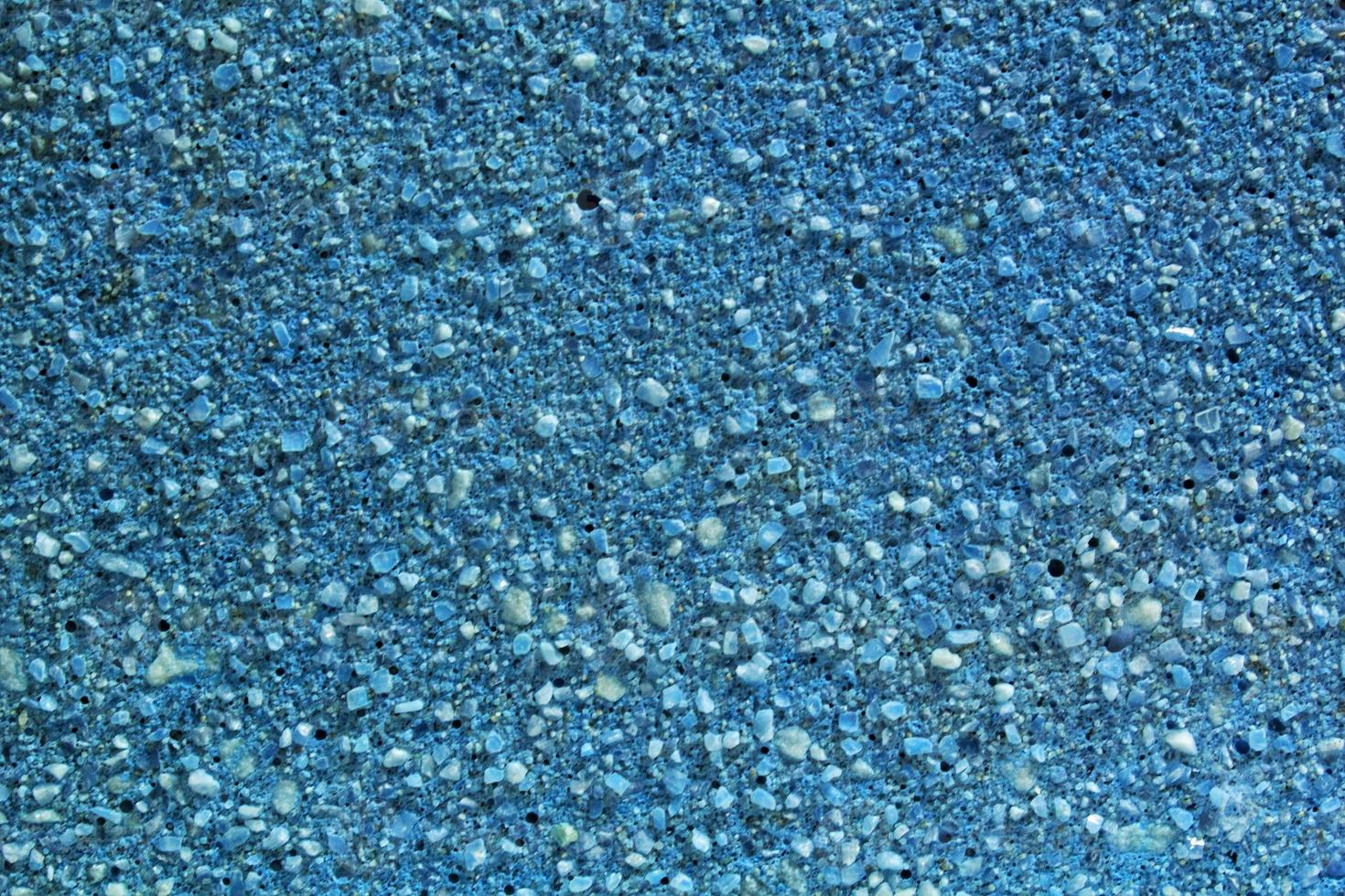 Concrete blue floor with marble small natural crushed stones inserted. Pebbles textured background. Decorative rough surface granite. Gravel wall material. Little rock backdrop photo