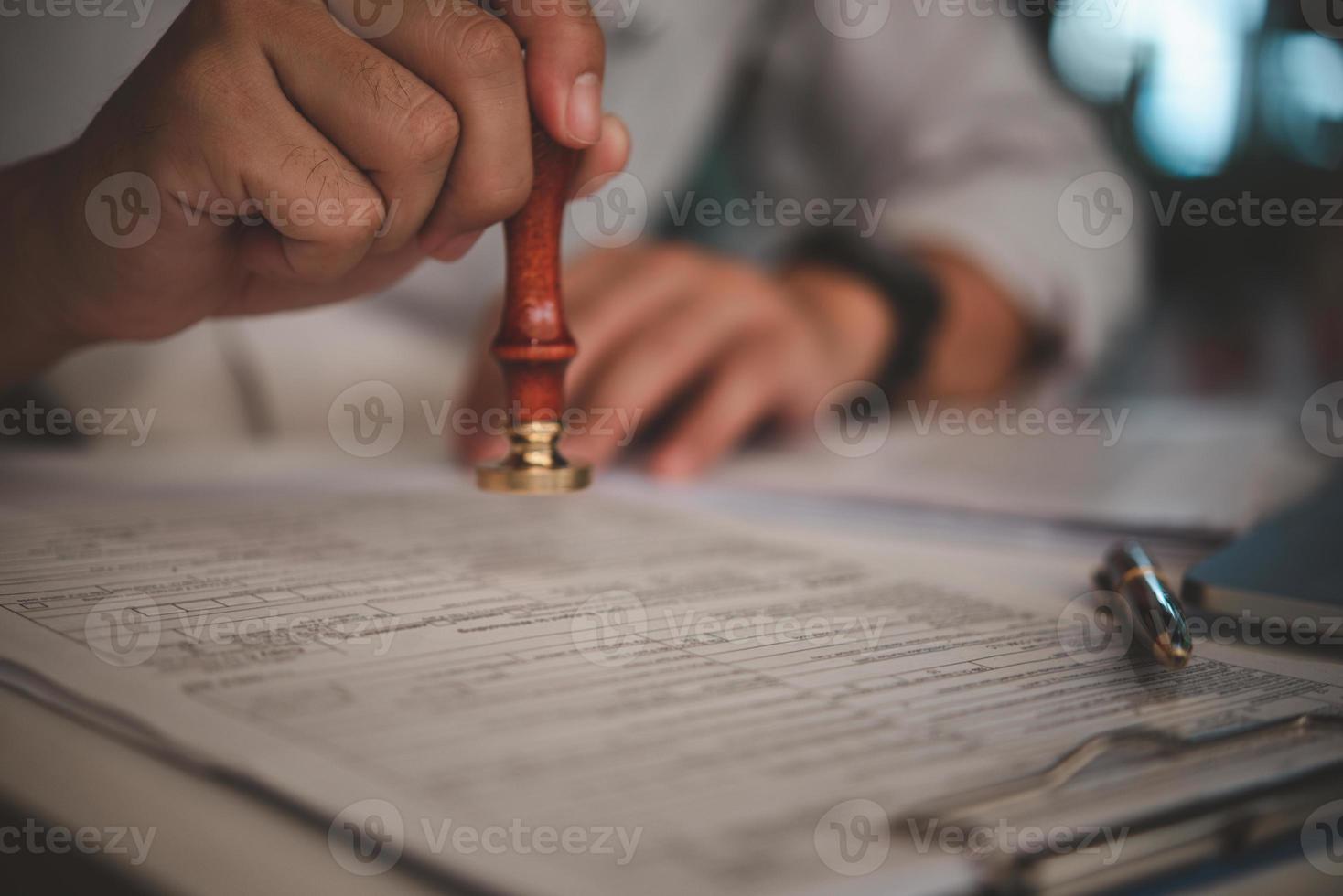 Man stamping approval of work finance banking or investment marketing documents on desk. photo