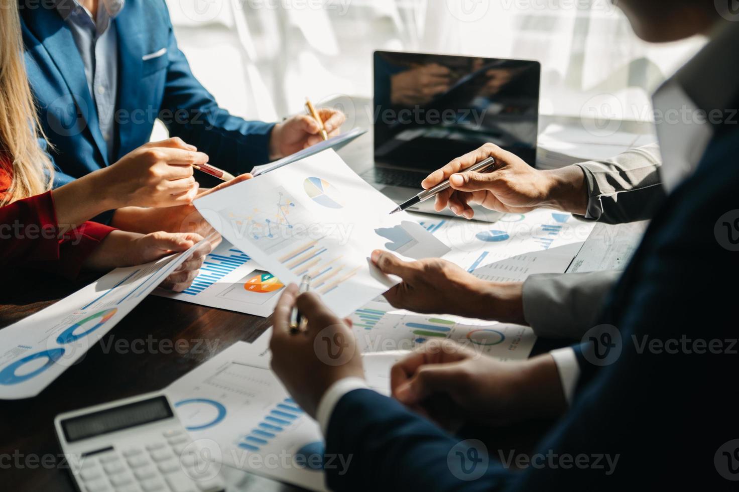 Business documents on office table with smart phone and calculator digital tablet and graph business with social network diagram and two colleagues discussing data working in the office photo