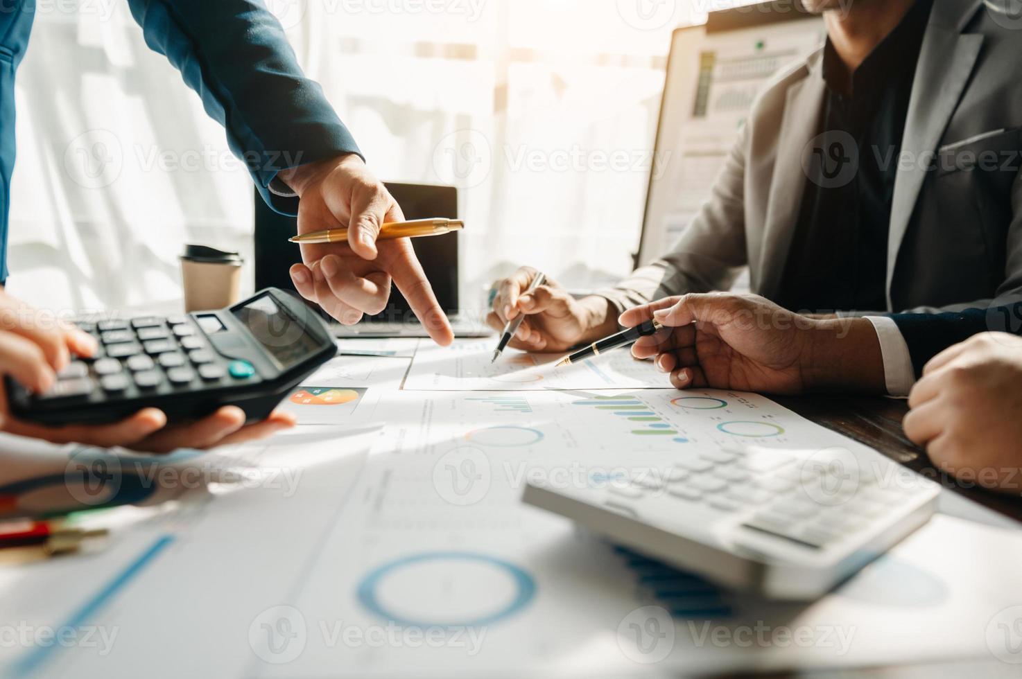 Business documents on office table with smart phone and calculator digital tablet and graph business with social network diagram and two colleagues discussing data working in the office photo