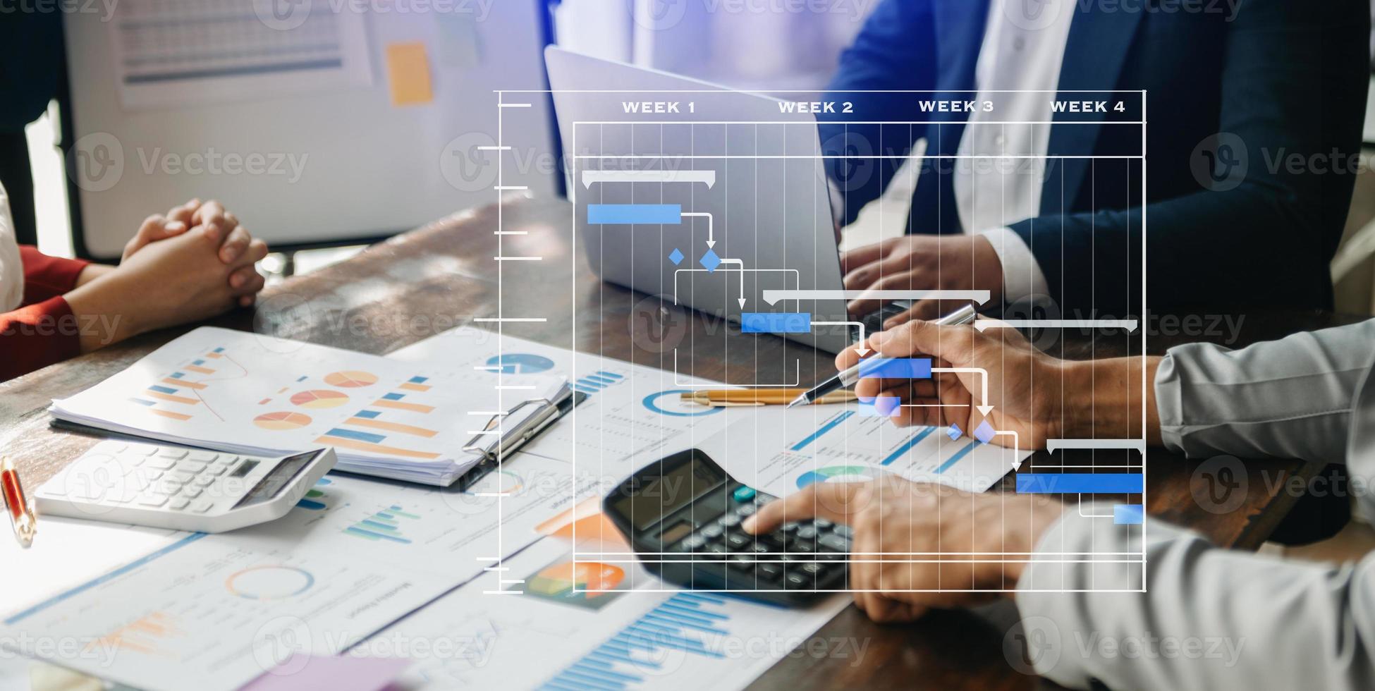 gerente de proyecto trabajando y actualizando tareas con hitos de planificación de progreso y diagrama de programación de diagramas de gantt. negocios que trabajan con teléfonos inteligentes, tabletas y computadoras portátiles en la oficina. foto