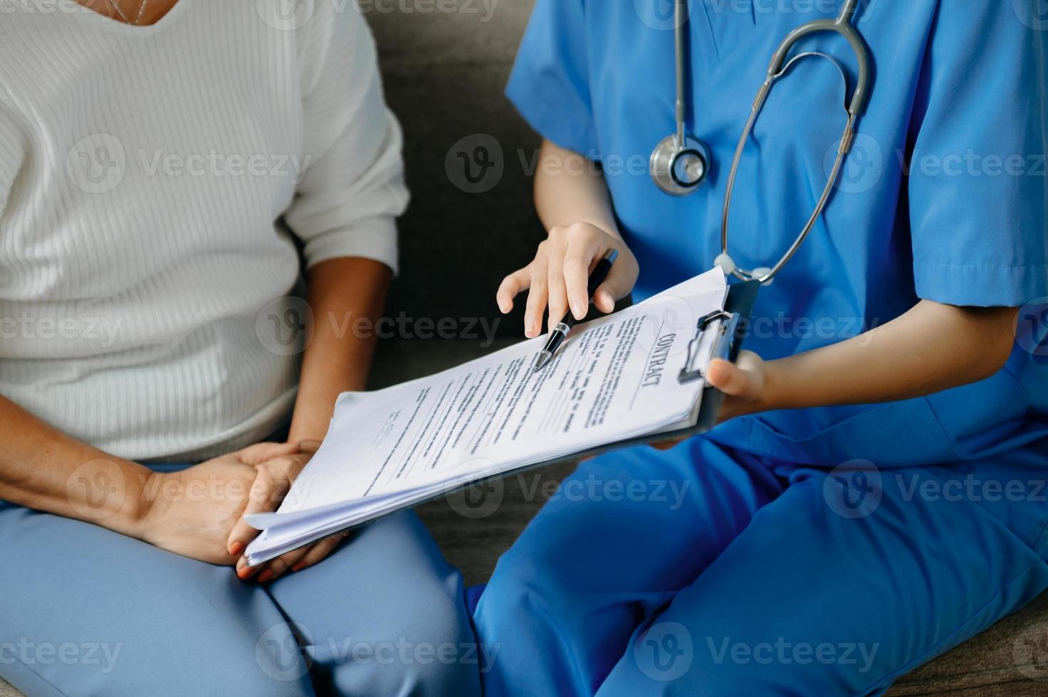 A professional physician talks to discuss results or symptoms and gives a recommendation to a male patient and signs a medical paper at an appointment visit. photo