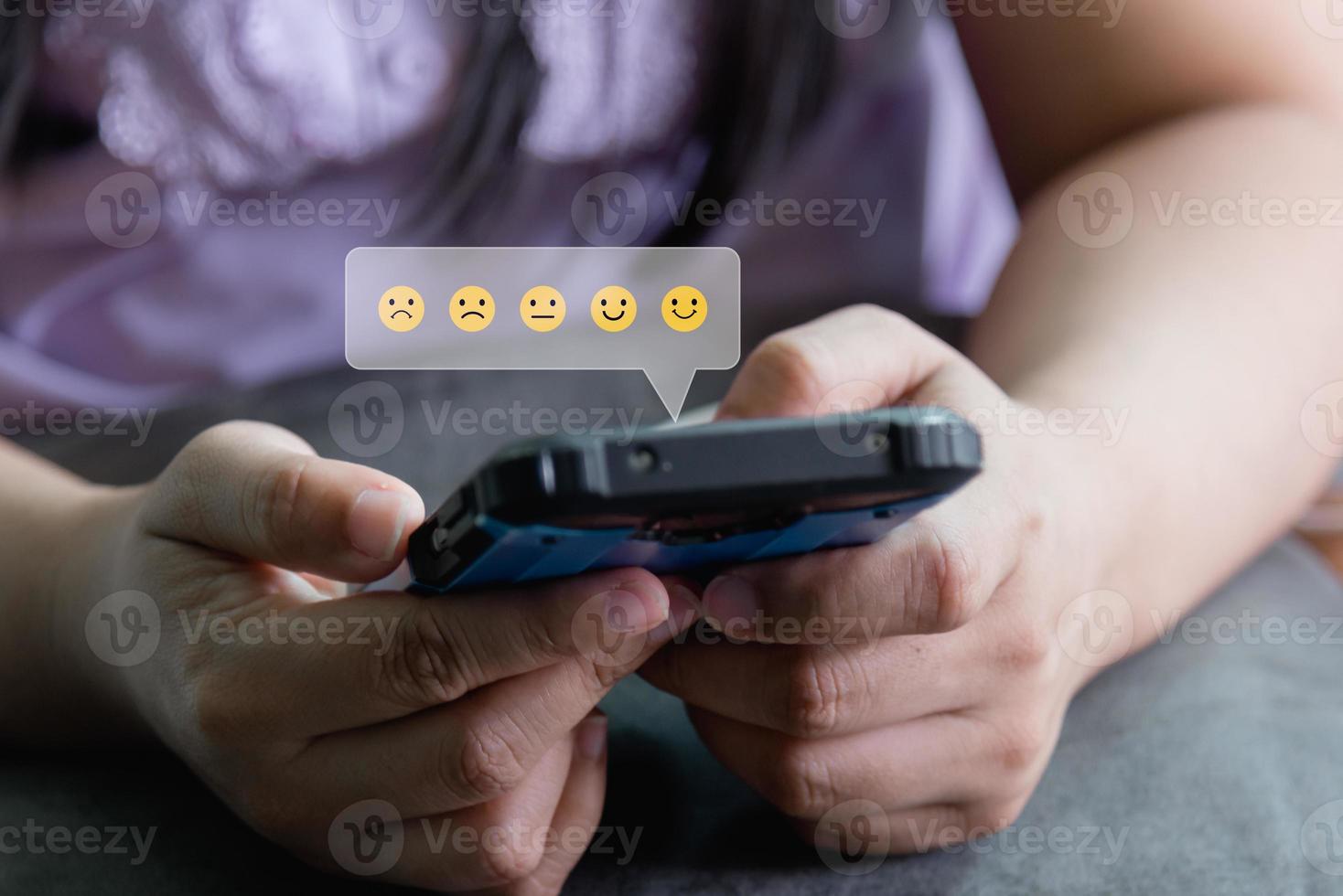 Customer service satisfaction evaluation concept. Man using smartphone and touching on screen with gold rating excellent feedback icon, Rated a very good review. photo