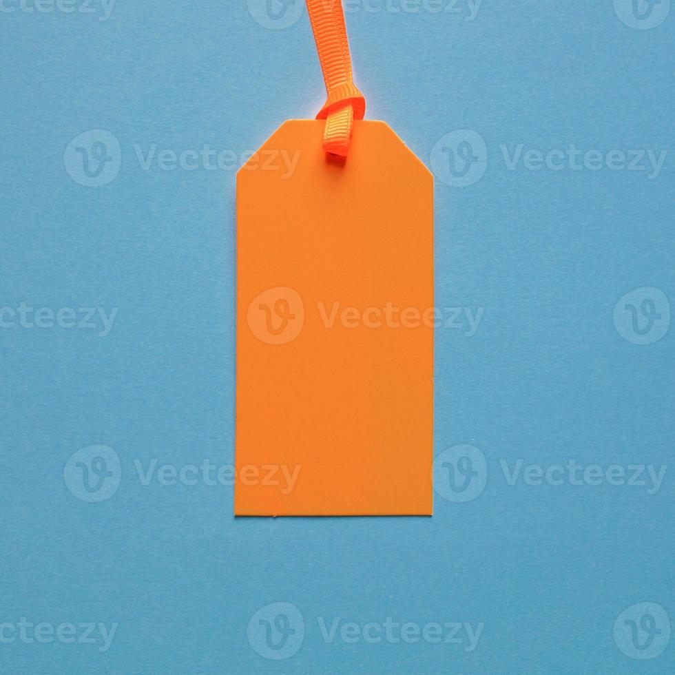 orange price tag on the blue background photo