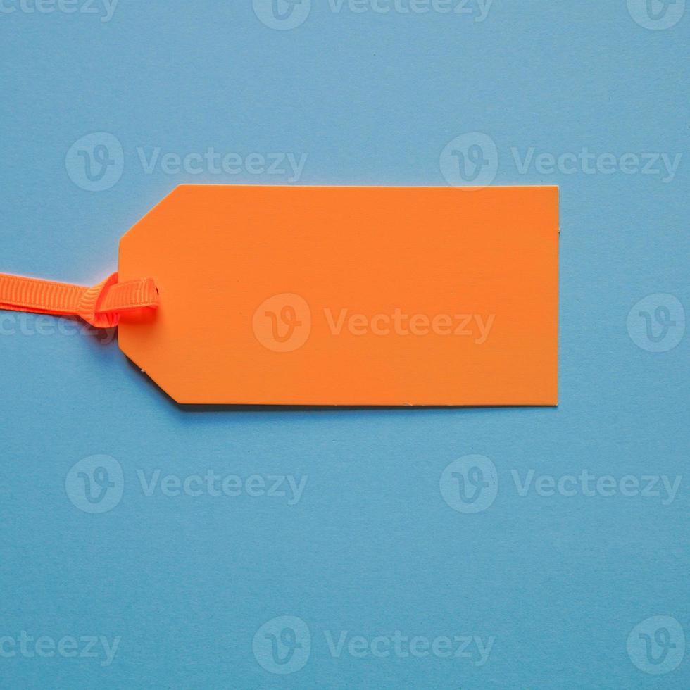 orange price tag on the blue background photo