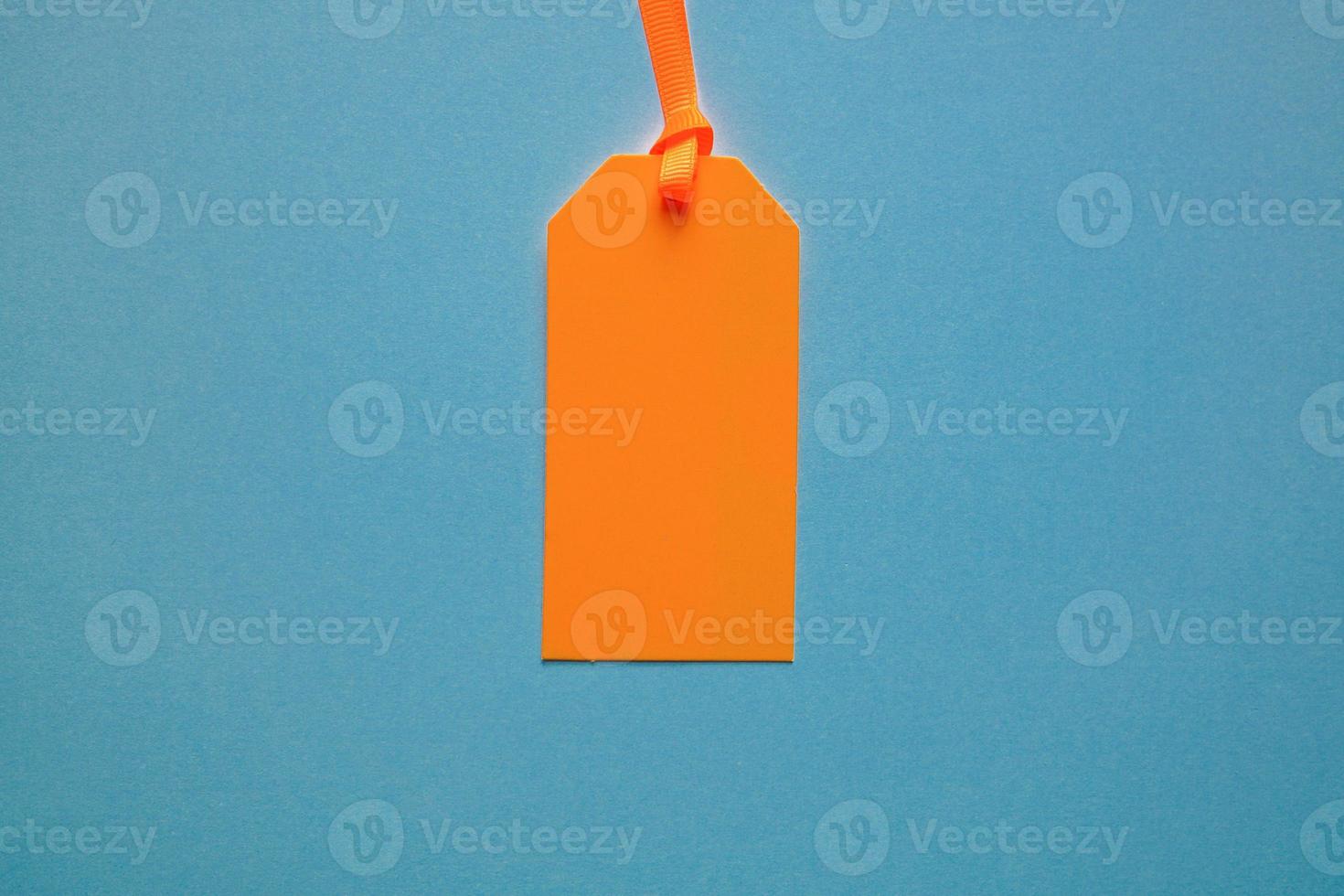 orange price tag on the blue background photo