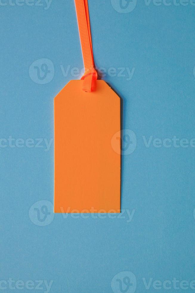 orange price tag on the blue background photo