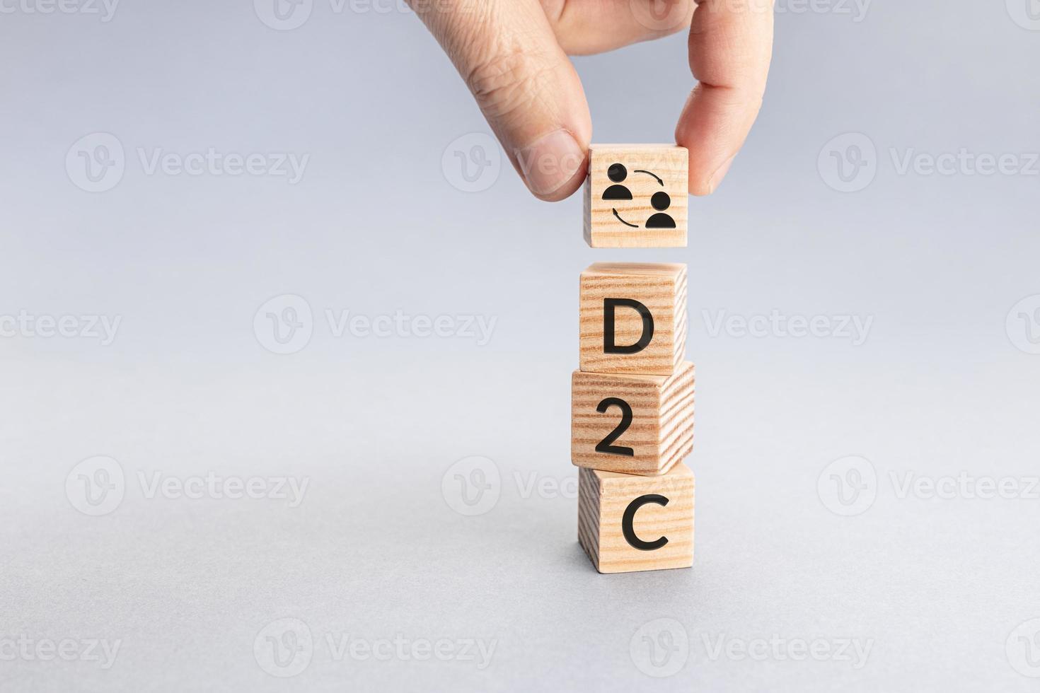Direct to Customer D2C concept. Hand putting a block with icon and text word on top of others. Copy space photo